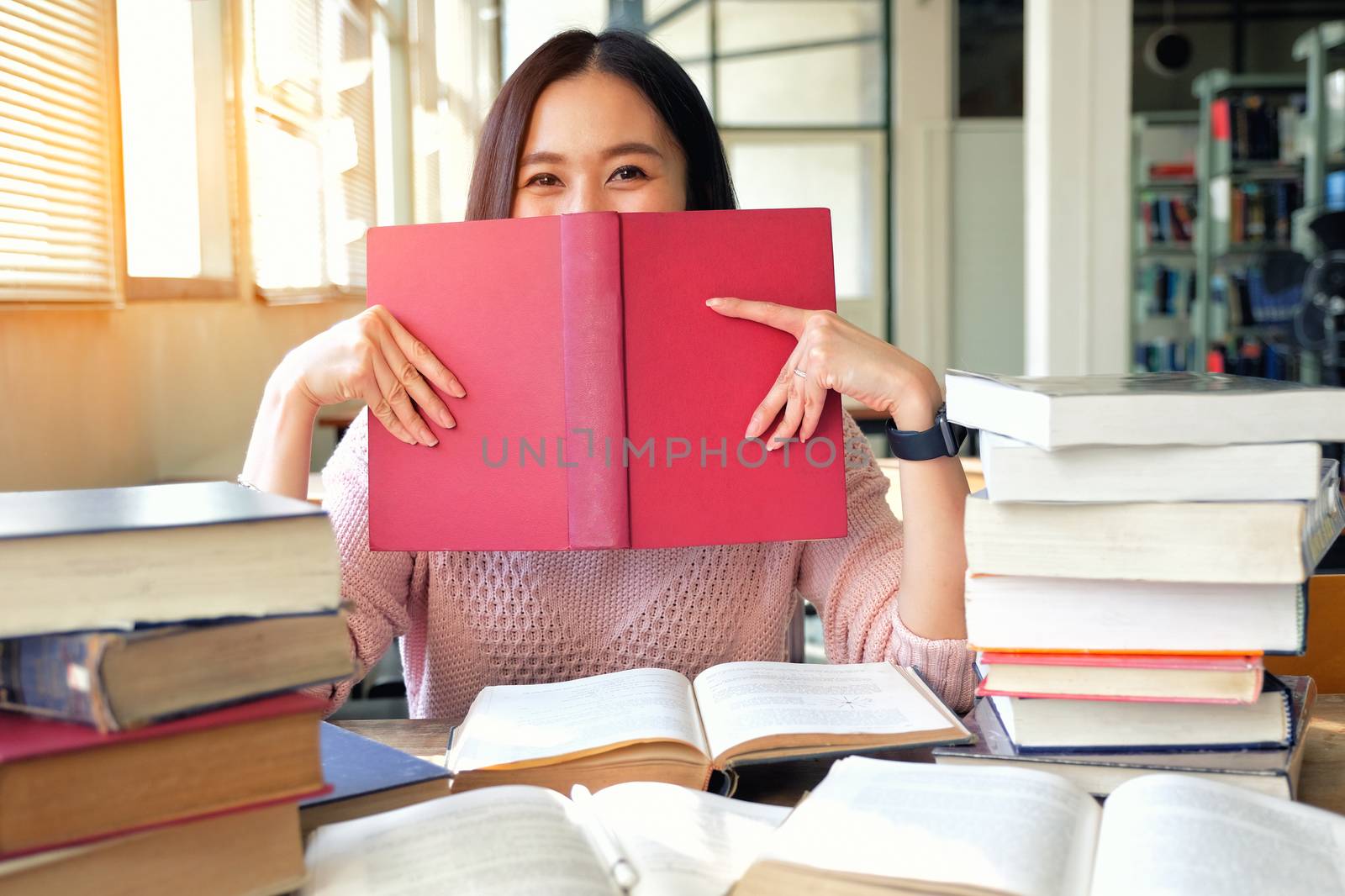 Young woman studying in library by Surasak