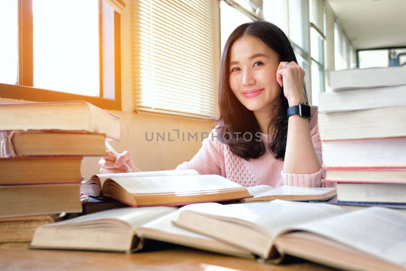 Young woman taking note and studying in library