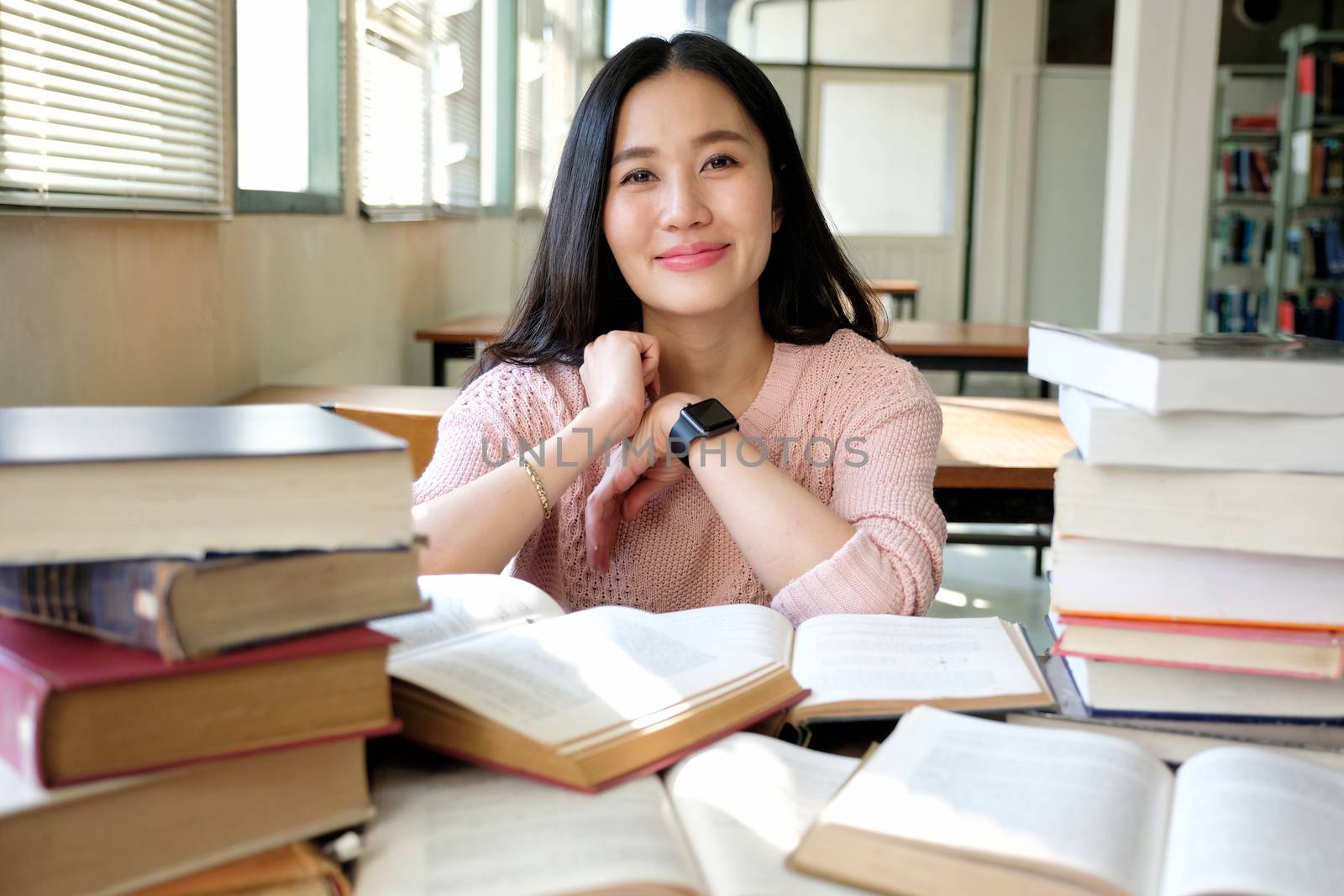 Young woman taking note and studying in library