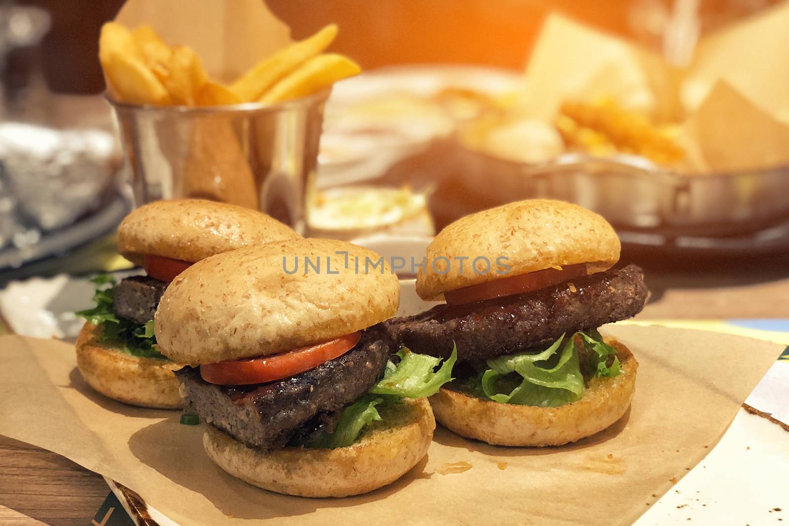 Fresh tasty meat burger and french fries on wooden table by Surasak