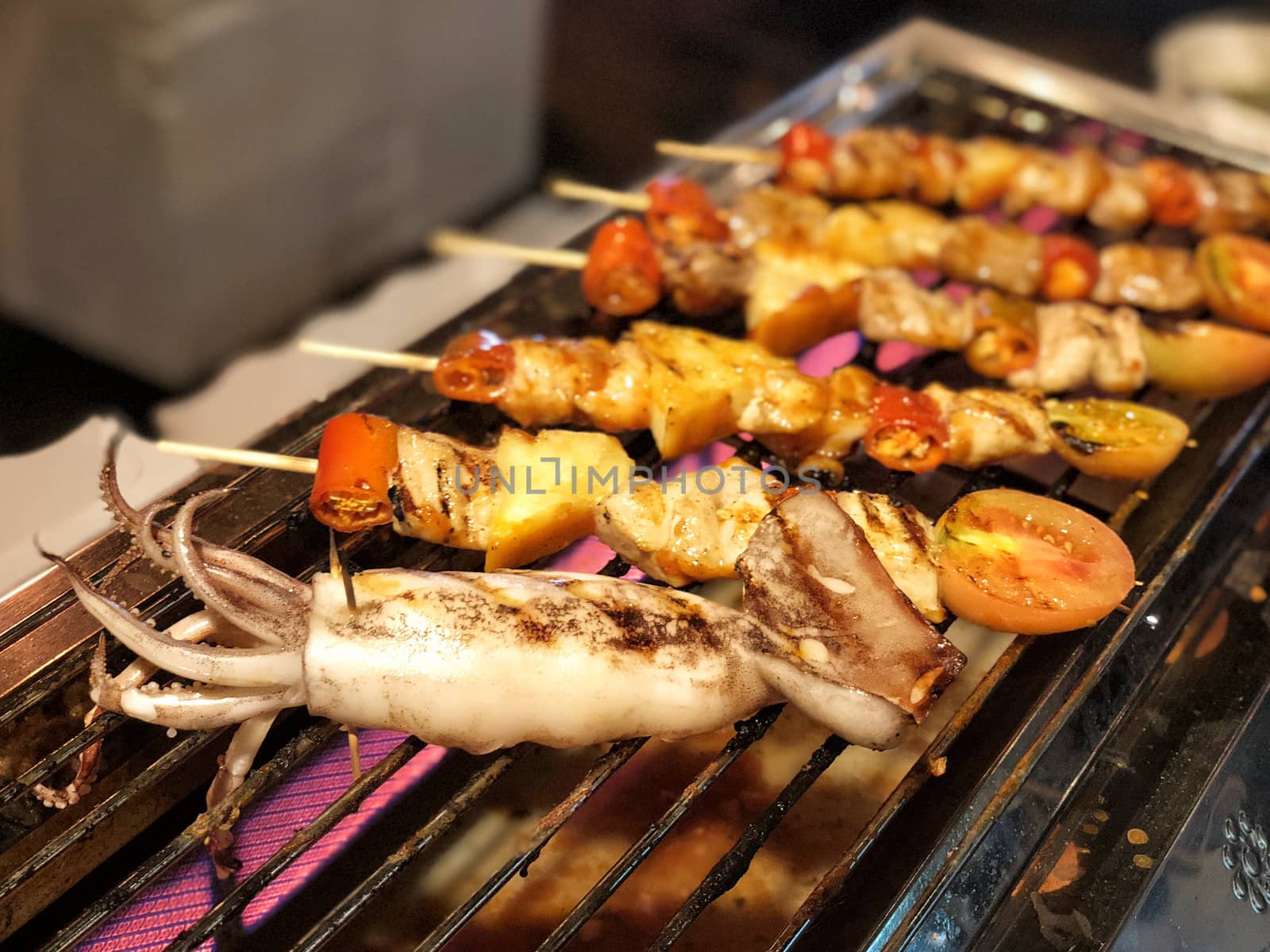 Squid chicken and pork and various vegetables on barbecue grill cooked 
