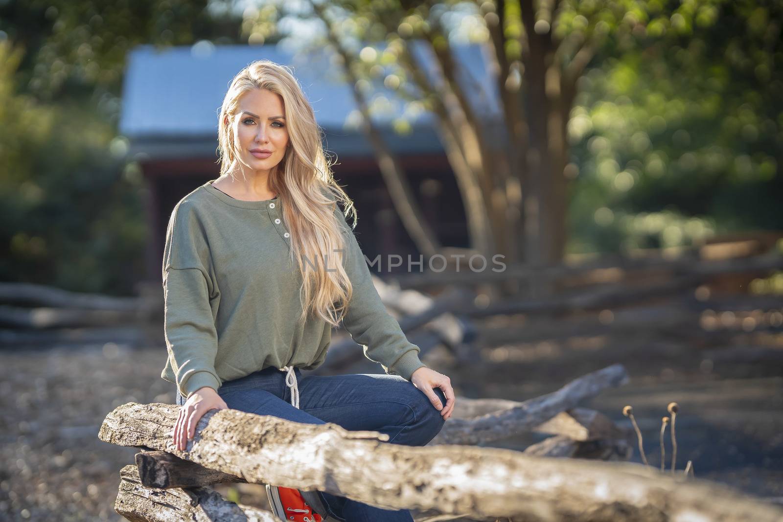 A gorgeous blonde model poses outdoors in her fall clothes