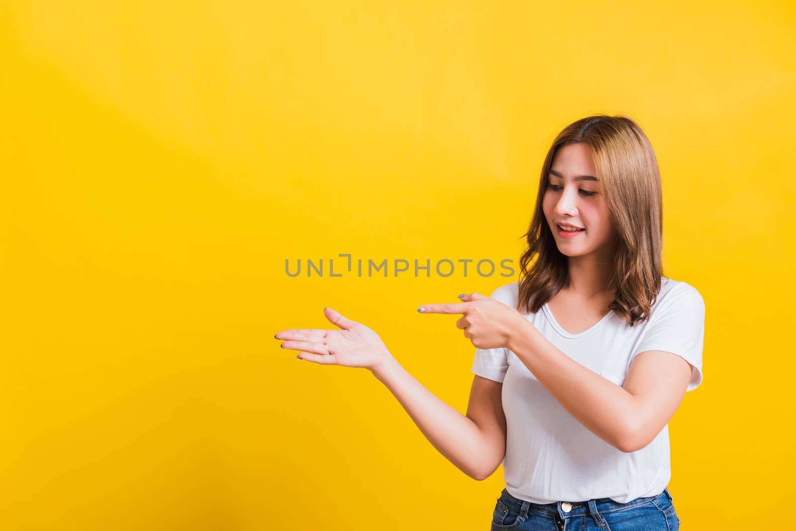 woman teen standing holding something on palm and point away sid by Sorapop