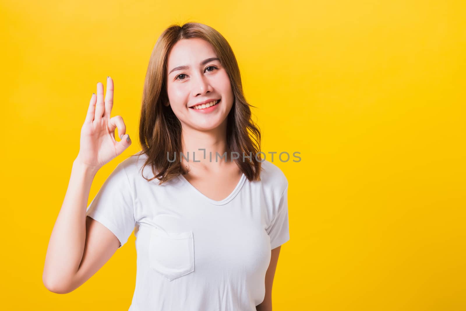 woman teen standing wear t-shirt showing gesturing ok sign by Sorapop