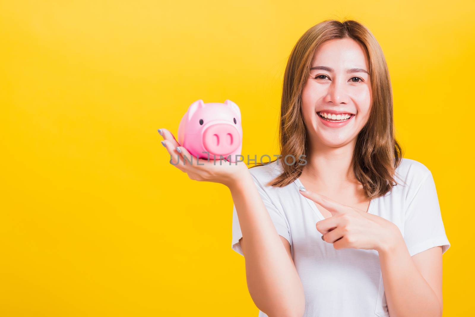 woman smiling hold piggy bank with a lots money by Sorapop