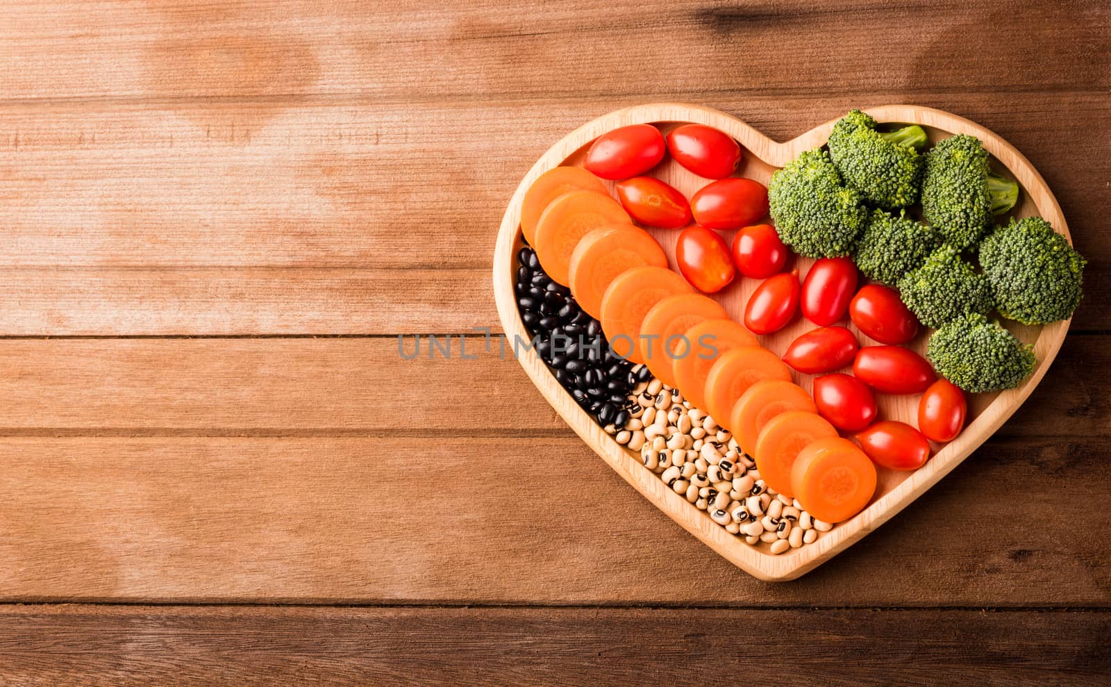 Top view of fresh organic fruits and vegetables in heart plate wood (carrot, Broccoli, tomato) on wooden table, Healthy lifestyle diet food concept