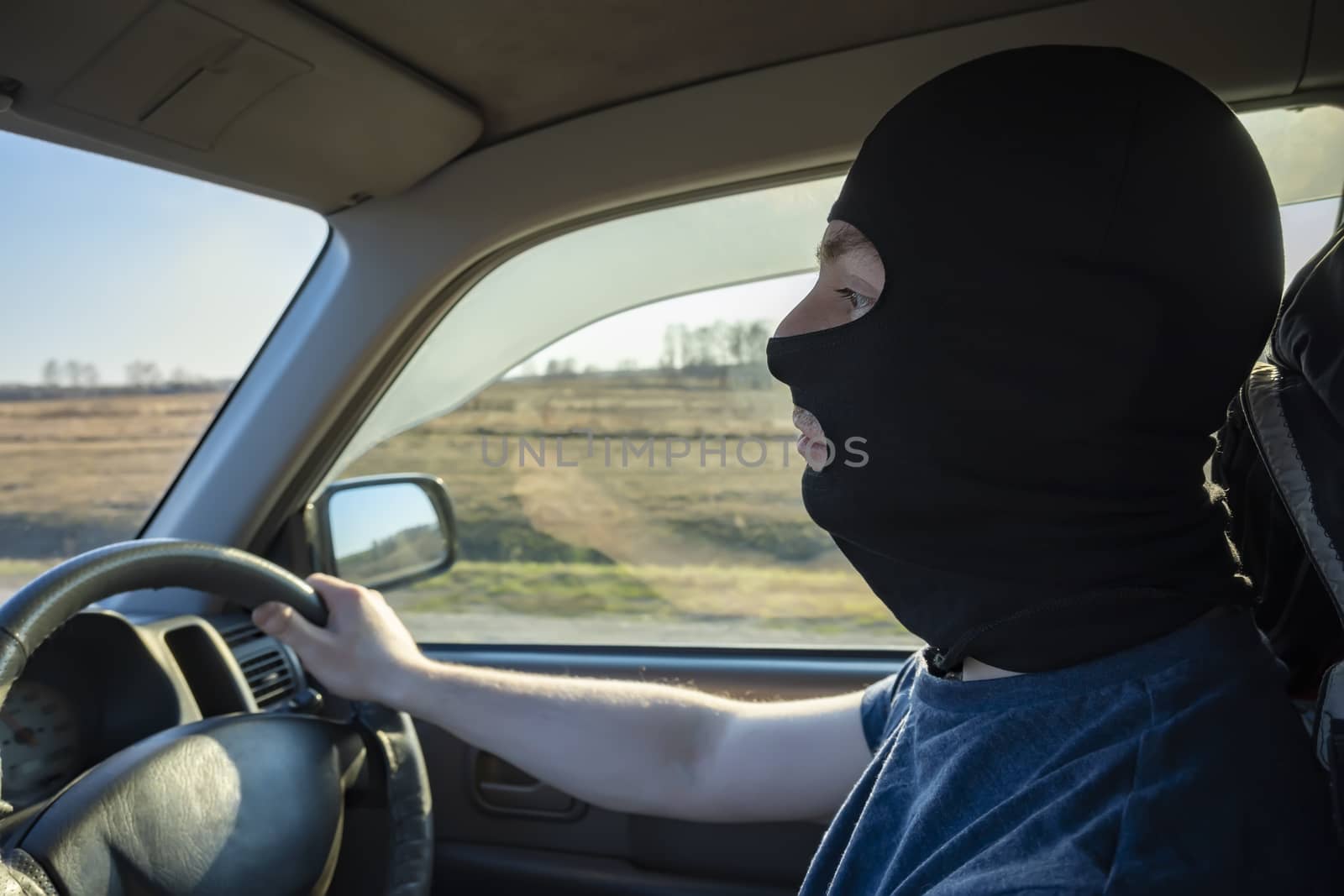 bandit, a black masked driver who drives a car on a country highway by jk3030