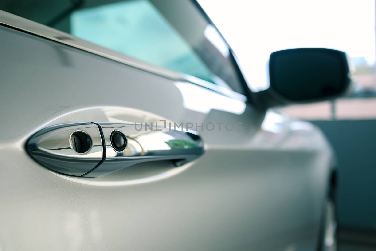 door handle of modern car parked at parking lot of condominium, push button to lock vehicle, keyless entry door handle, selective focus