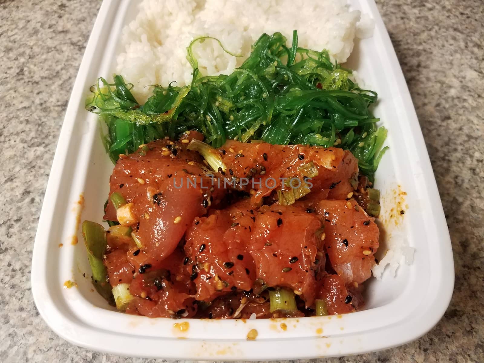 raw tuna fish Hawaiian poke with seaweed and rice in container on counter