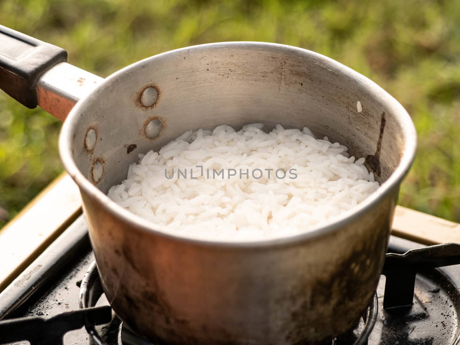 Closeup of a pot for cooking rice on a gas burner in breakfast a by TEERASAK