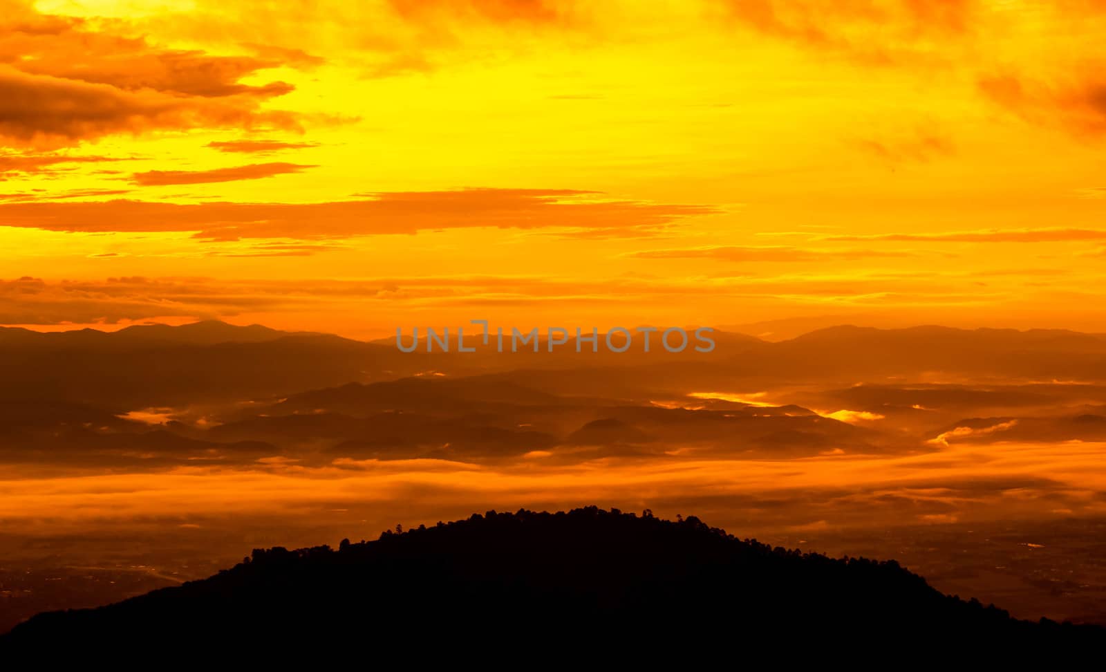 Beautiful landscape at sunset sky with clouds on peak of mountains.