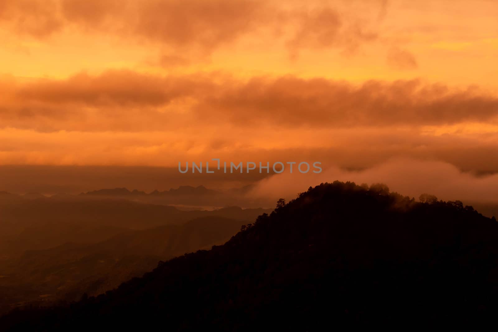 Beautiful landscape at sunset sky with clouds on peak of mountains.