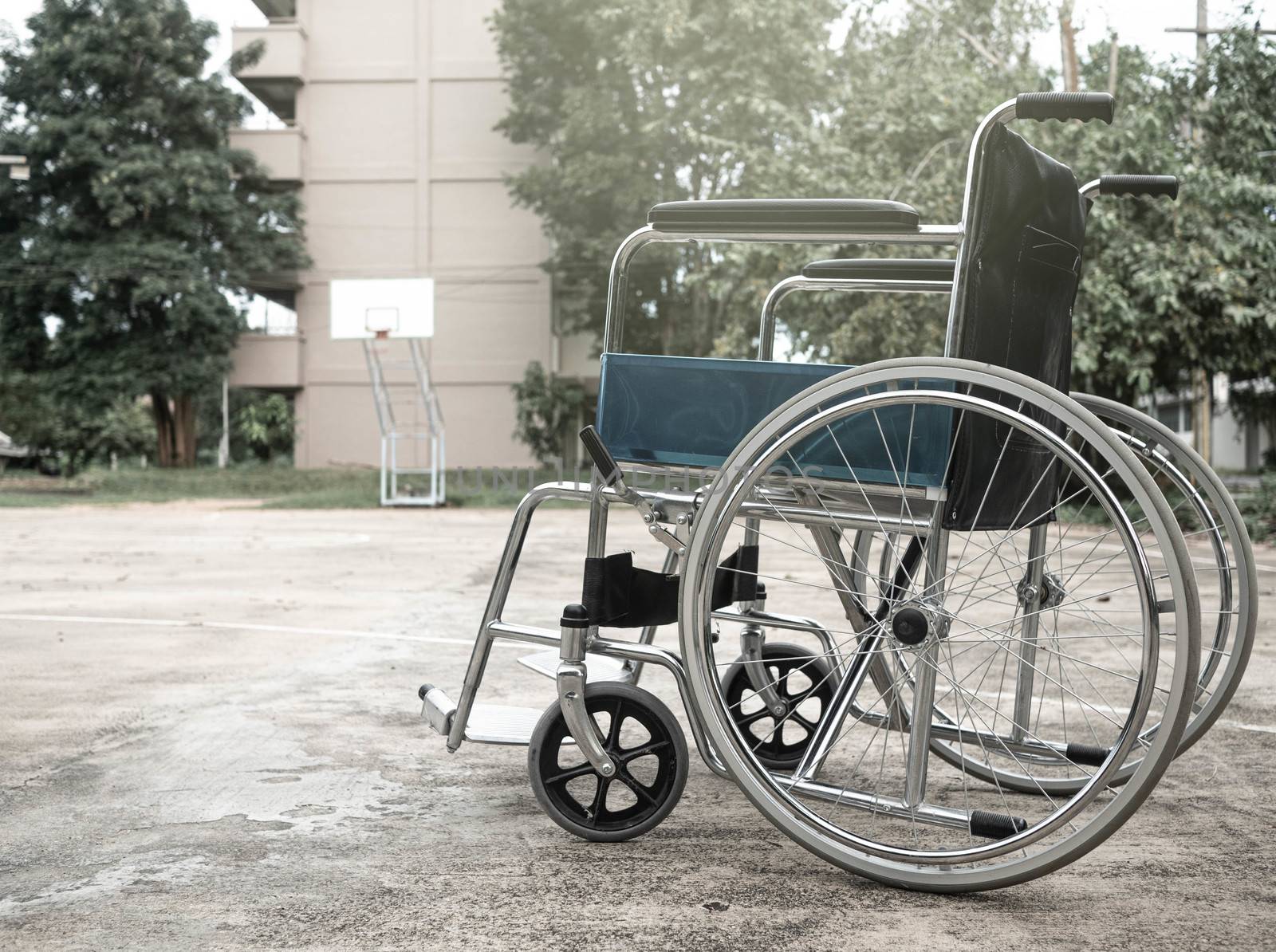 Empty wheelchair parked in the park. by TEERASAK