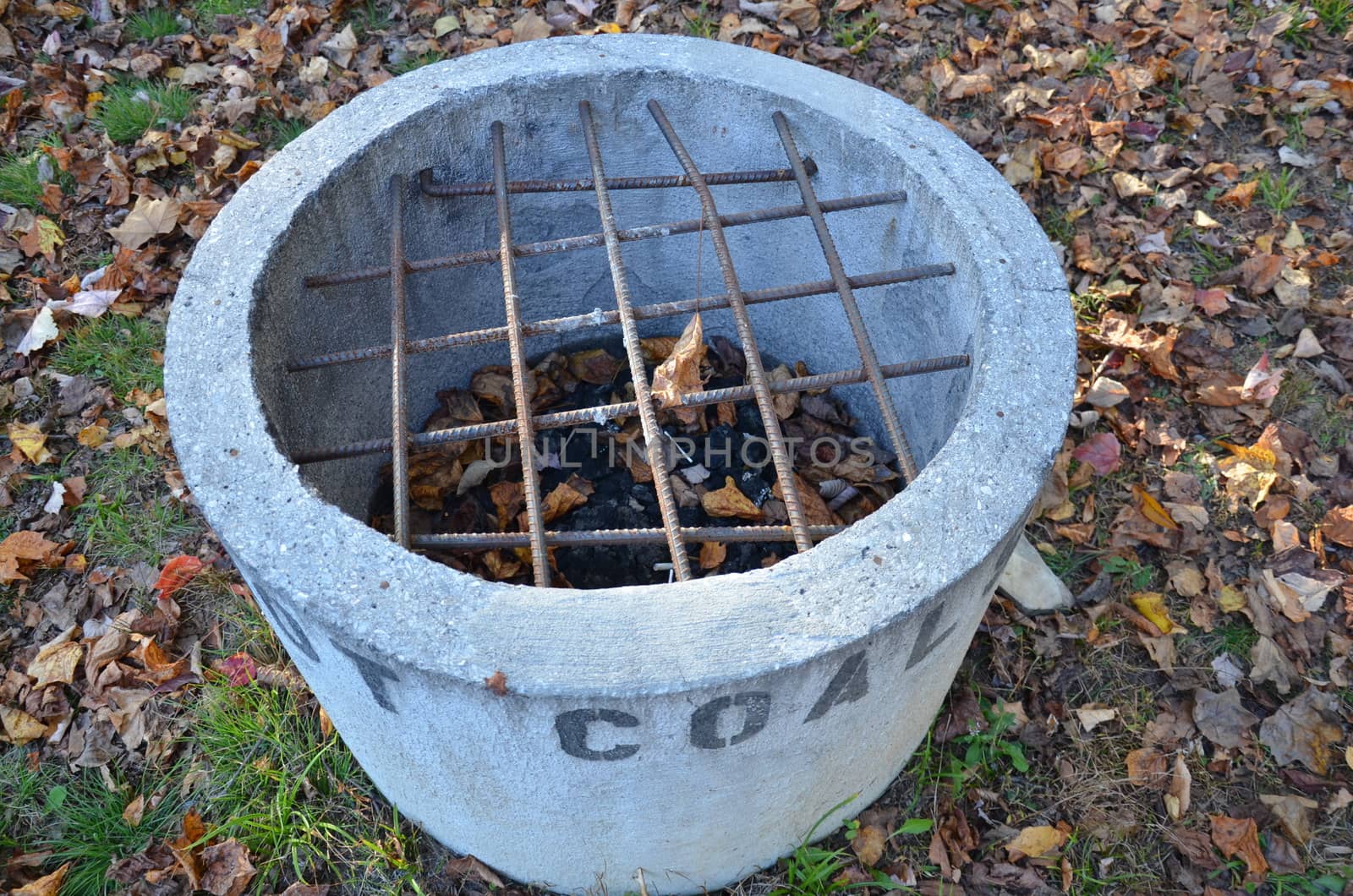 cement hot coal container or bin with metal bars and leaves