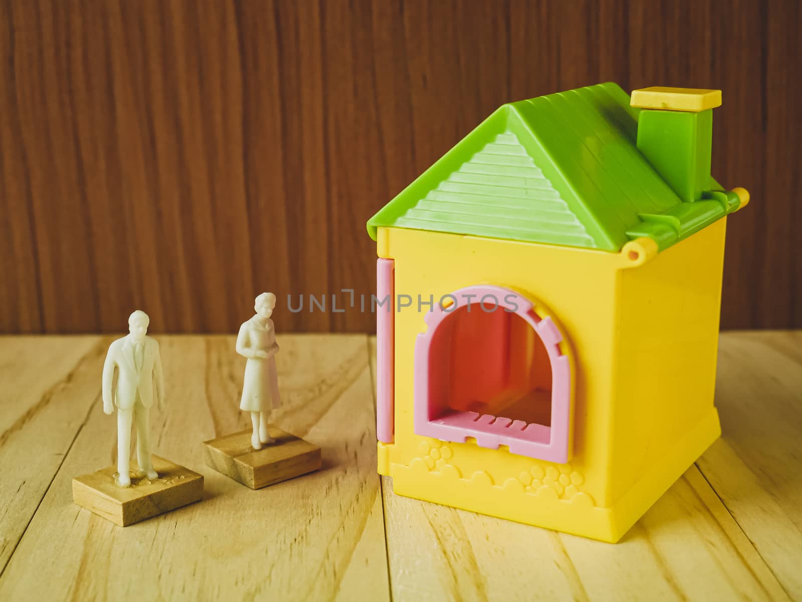 The home toy  and white human figure on wood table for property, building content.