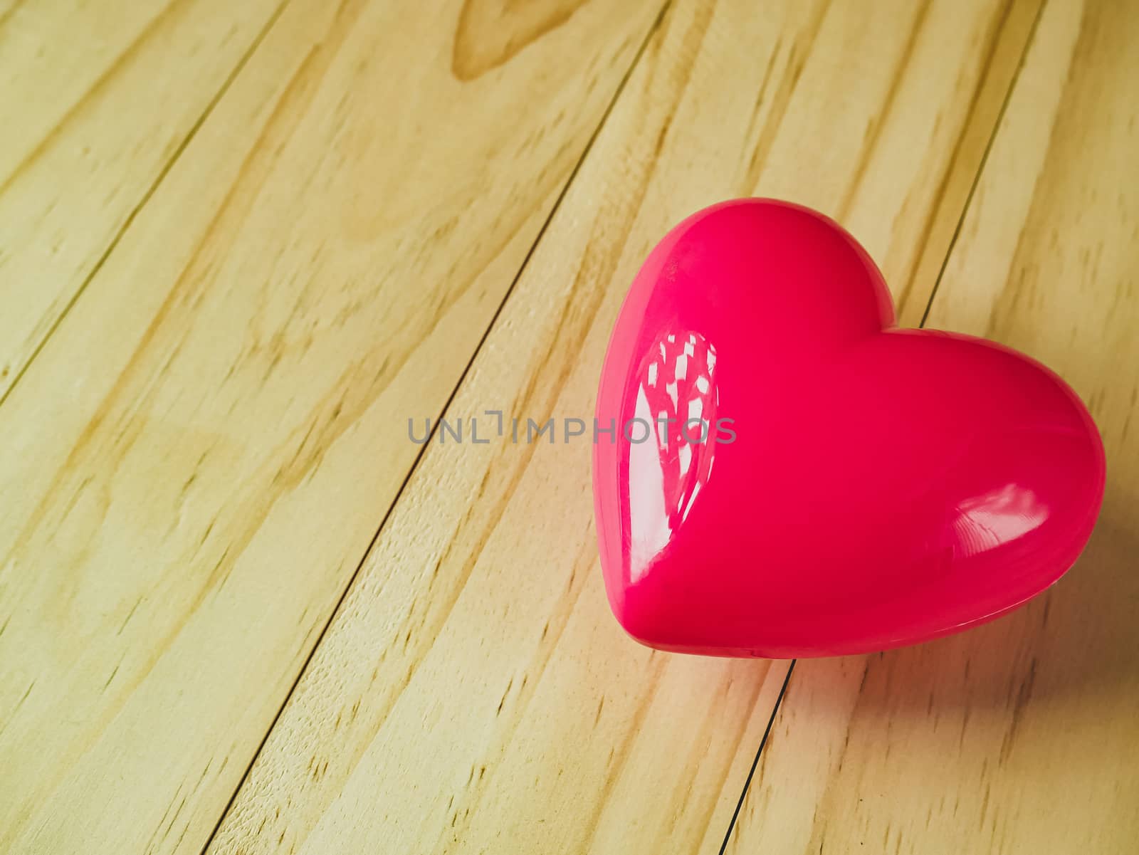 The pink heart on wood table for Health and medical content.
