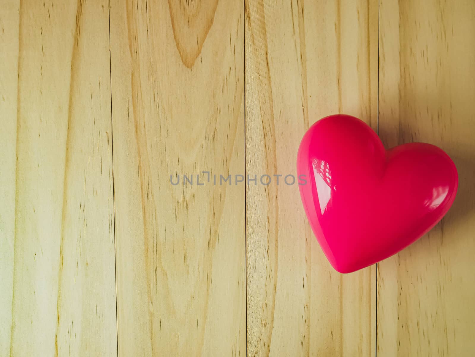  pink heart on wood table for Health and medical content.
 by Niphon_13