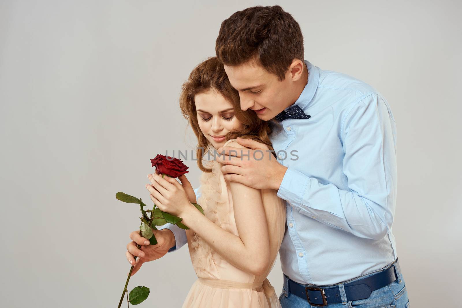 lovers men and woman hugs romance love red rose light background. High quality photo