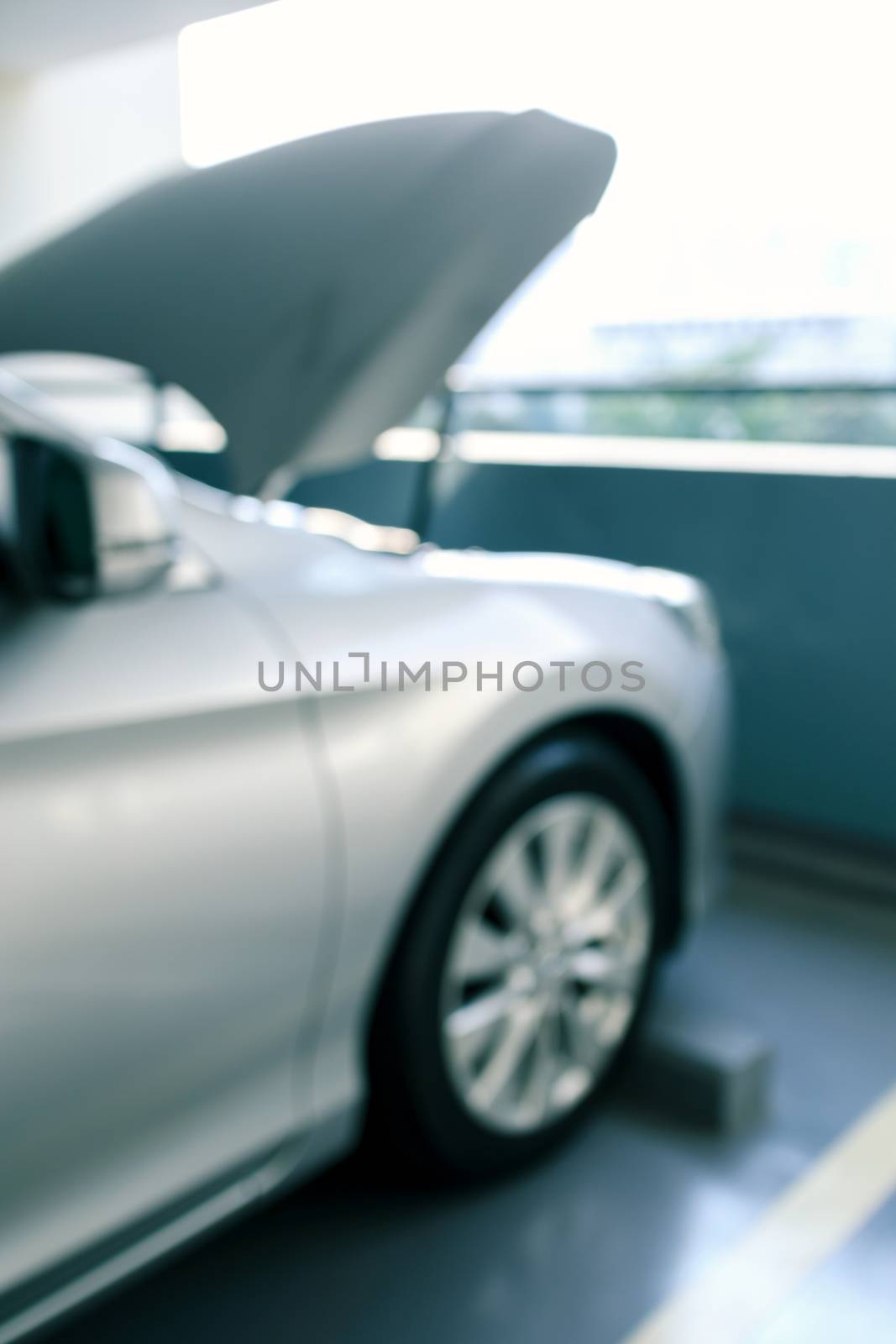 abstract blur and defocused modern car with bonnet or hood open, ready to be checked or fixed at parking lot of condominium for background