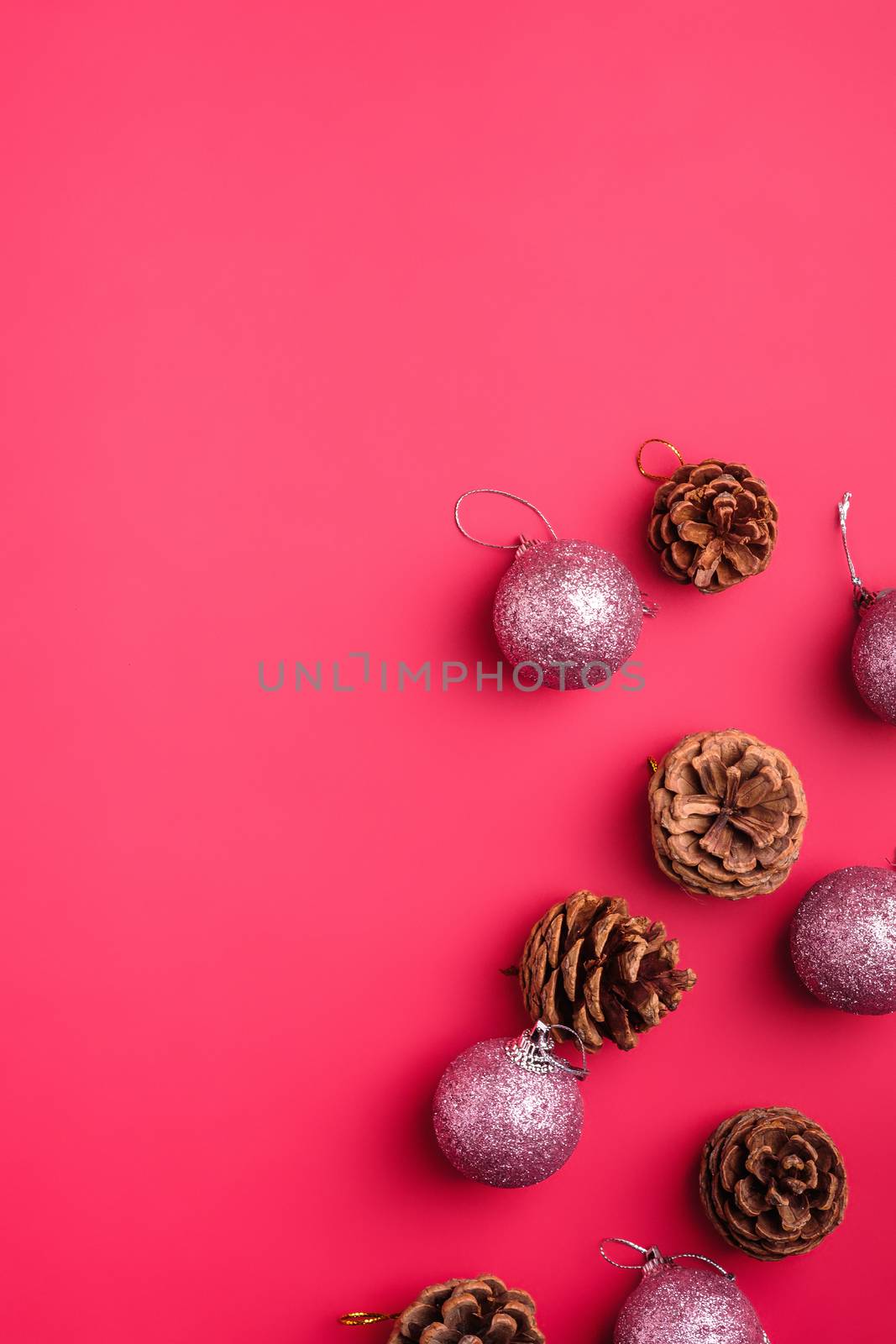 Christmas New Year composition. Gifts, fir tree cones, silver ball decorations on pink background. Winter holidays concept. Flat lay, top view, copy space