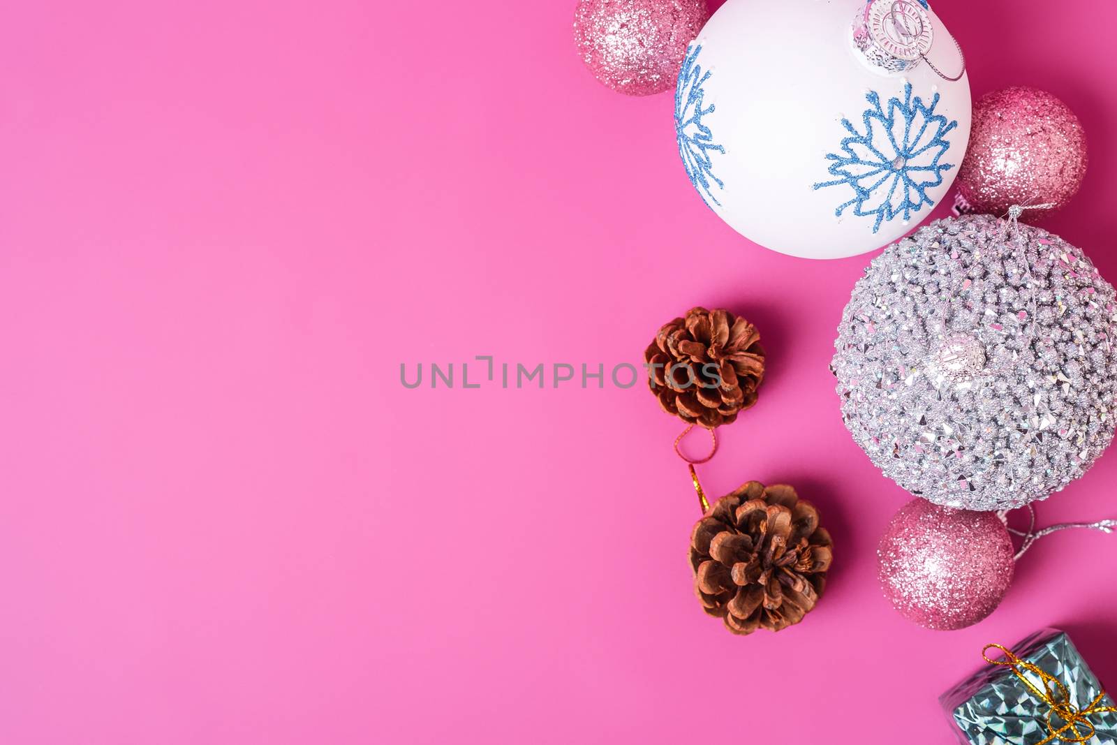 Christmas New Year composition. Gifts, fir tree cones, silver ball decorations on pink background. Winter holidays concept. Flat lay, top view, copy space