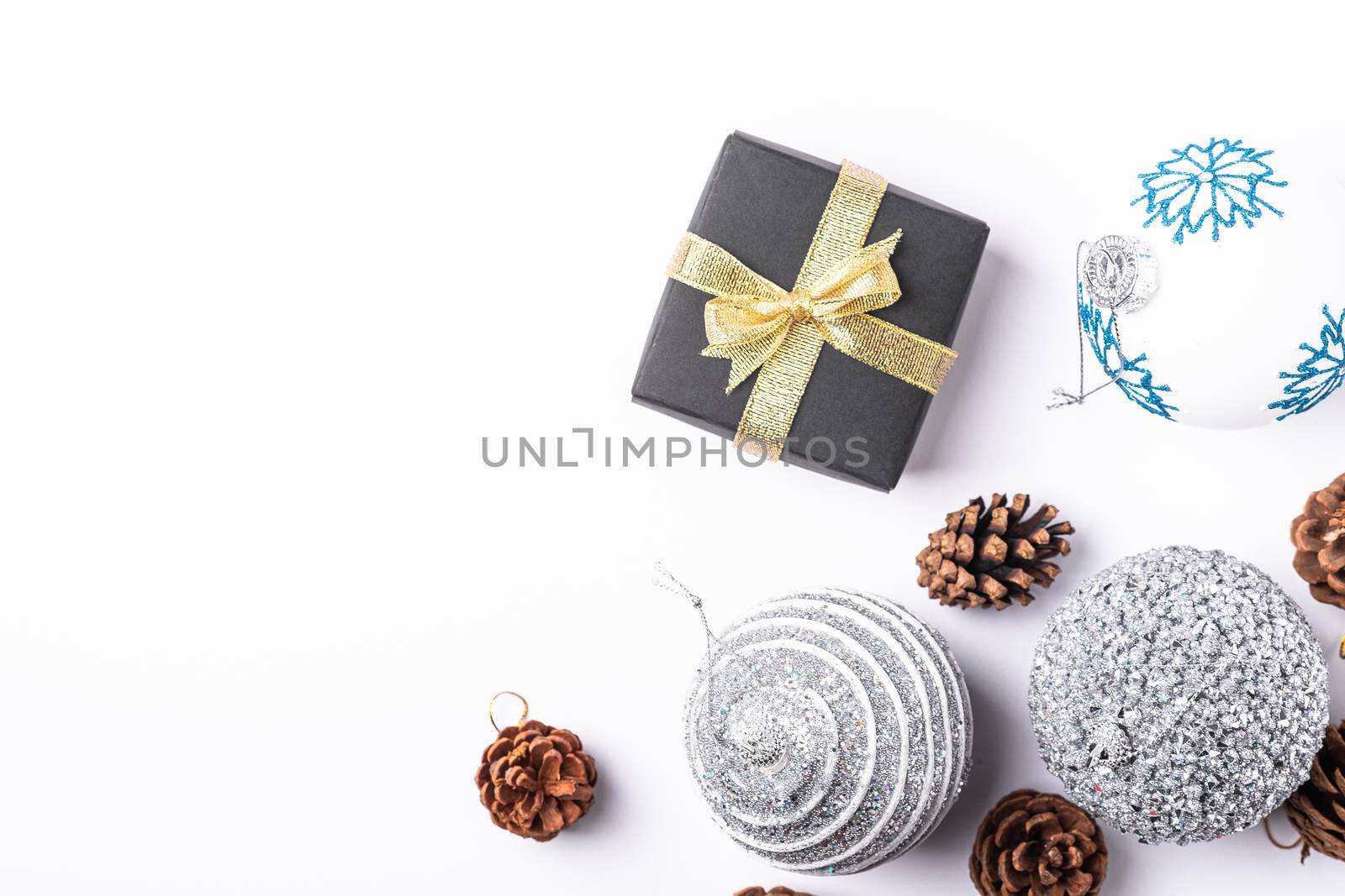 Christmas New Year composition. Gifts, fir tree cones, silver ball decorations on white background. Winter holidays concept. Flat lay, top view, copy space