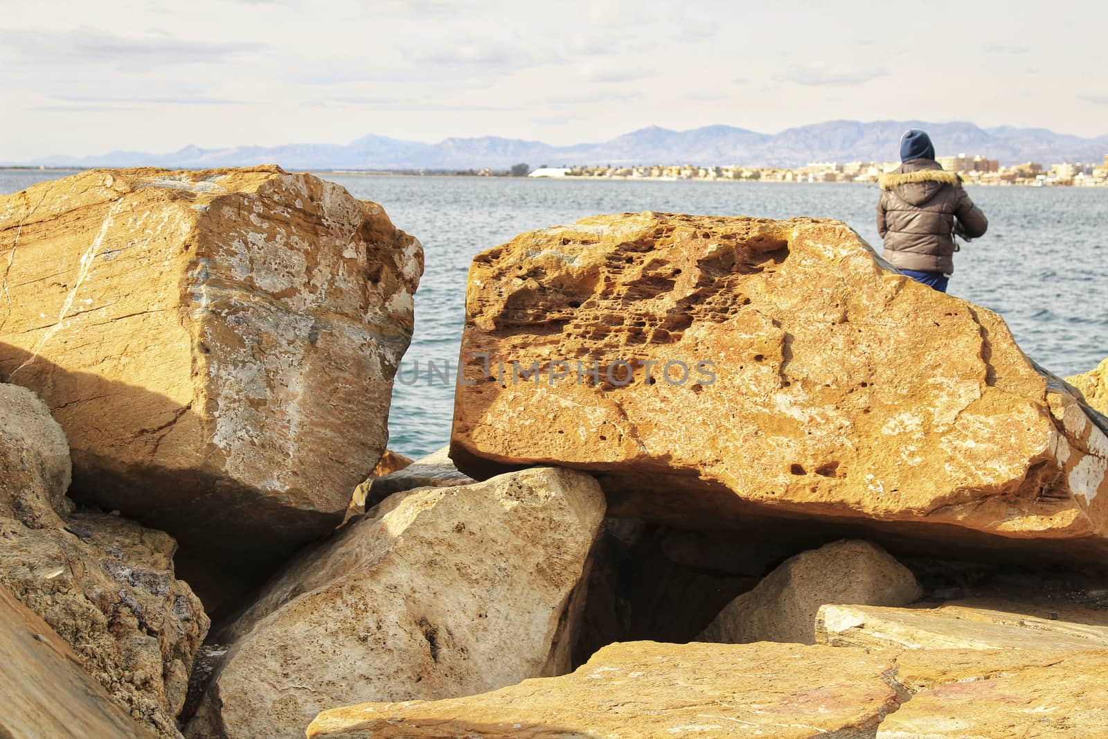 Santa Pola, Spain- December 7, 2017: Man Fishing and relaxing in the dock in a sunny day in Santa Pola, Alicante
