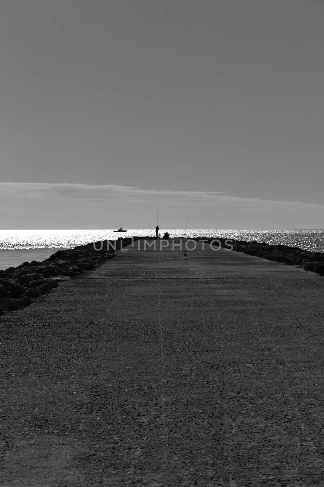 Fishing day on a breakwater under the sun in Santa Pola, Spain