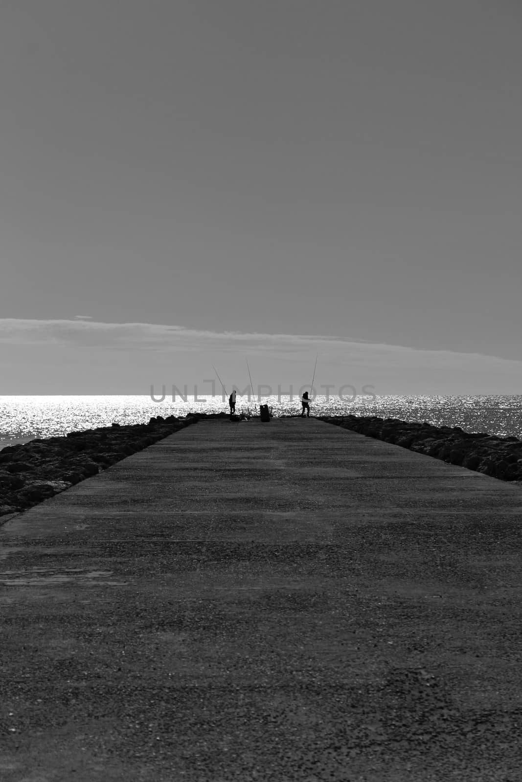 Fishing day on a breakwater under the sun in Santa Pola, Spain