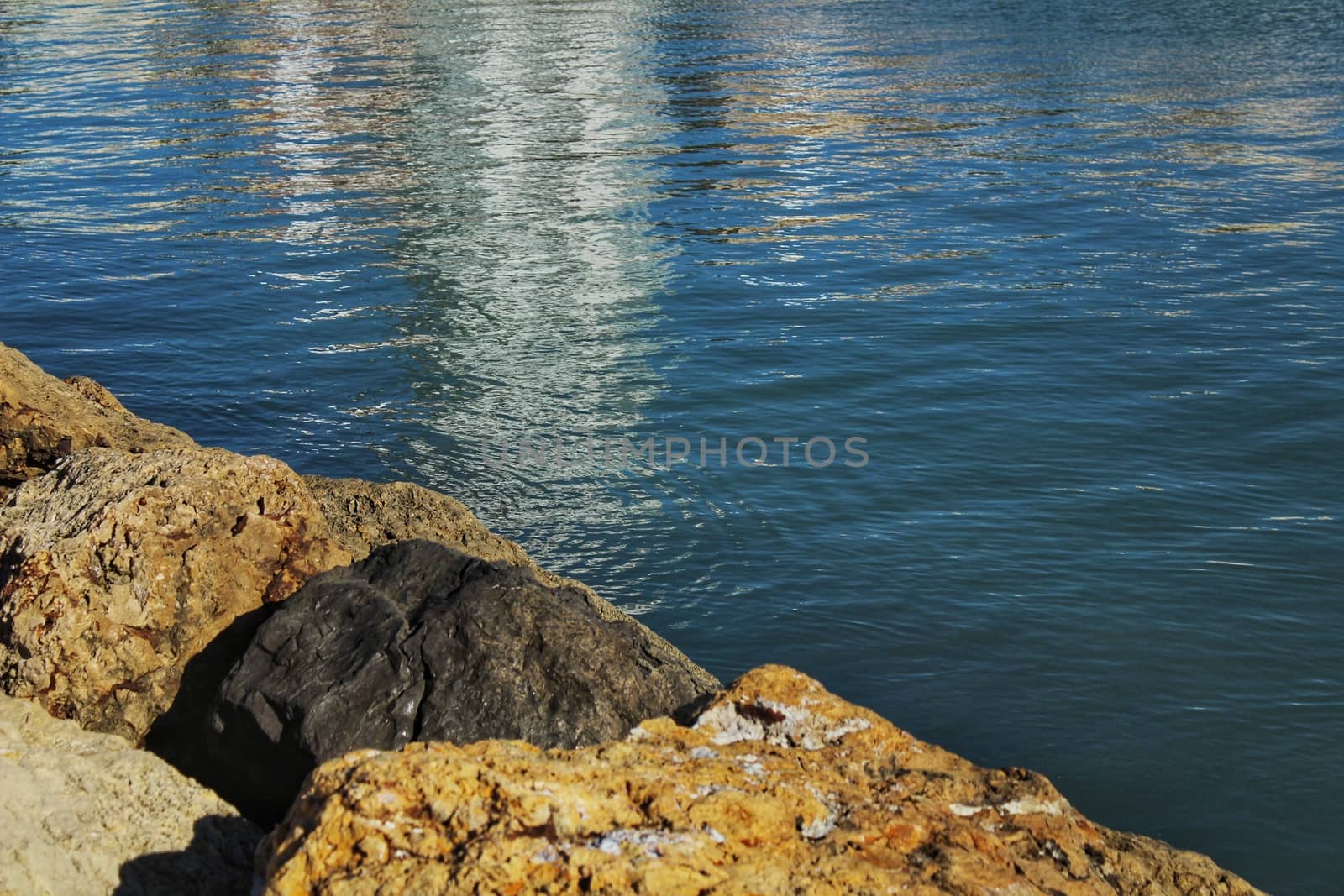 Reflections in the sea and rocks under the sun in Santa Pola, Spain