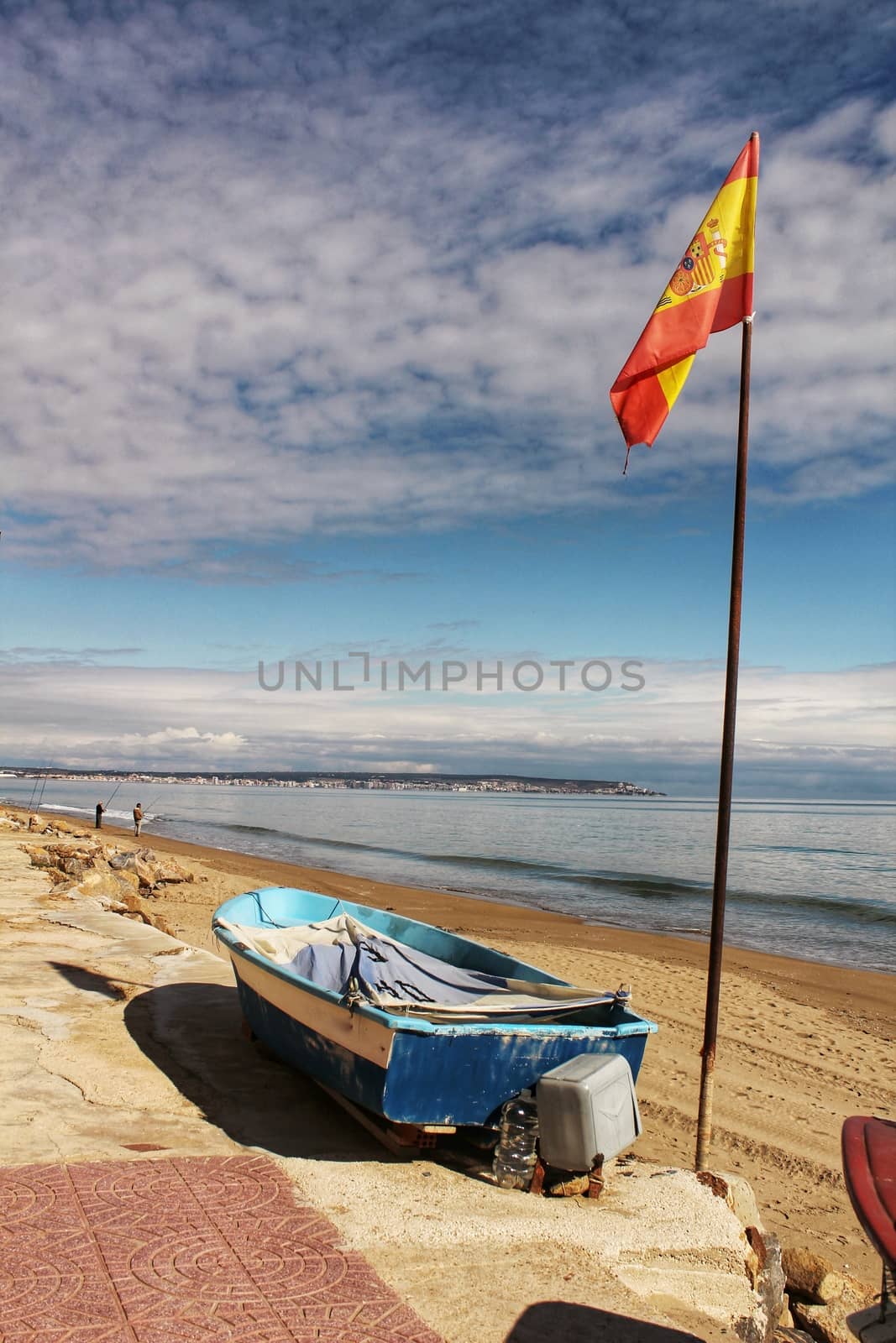Fishing boats on the shore under spanish flag in the morning