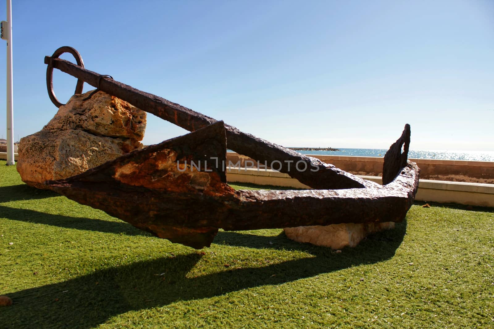 Santa Pola, Spain- February 16, 2018: Old anchor on a promenade of Santa Pola, Alicante. Mediterranean sea on background.