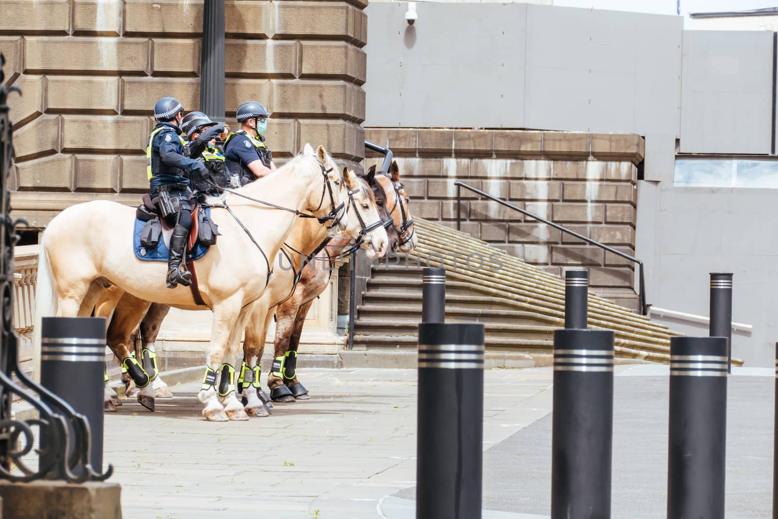Melbourne, Australia - October 18, 2020: Victoria police patrol Melbourne CBD streets and Parliament on horseback, checking on people during the Coronavirus pandemic and associated lockdown.