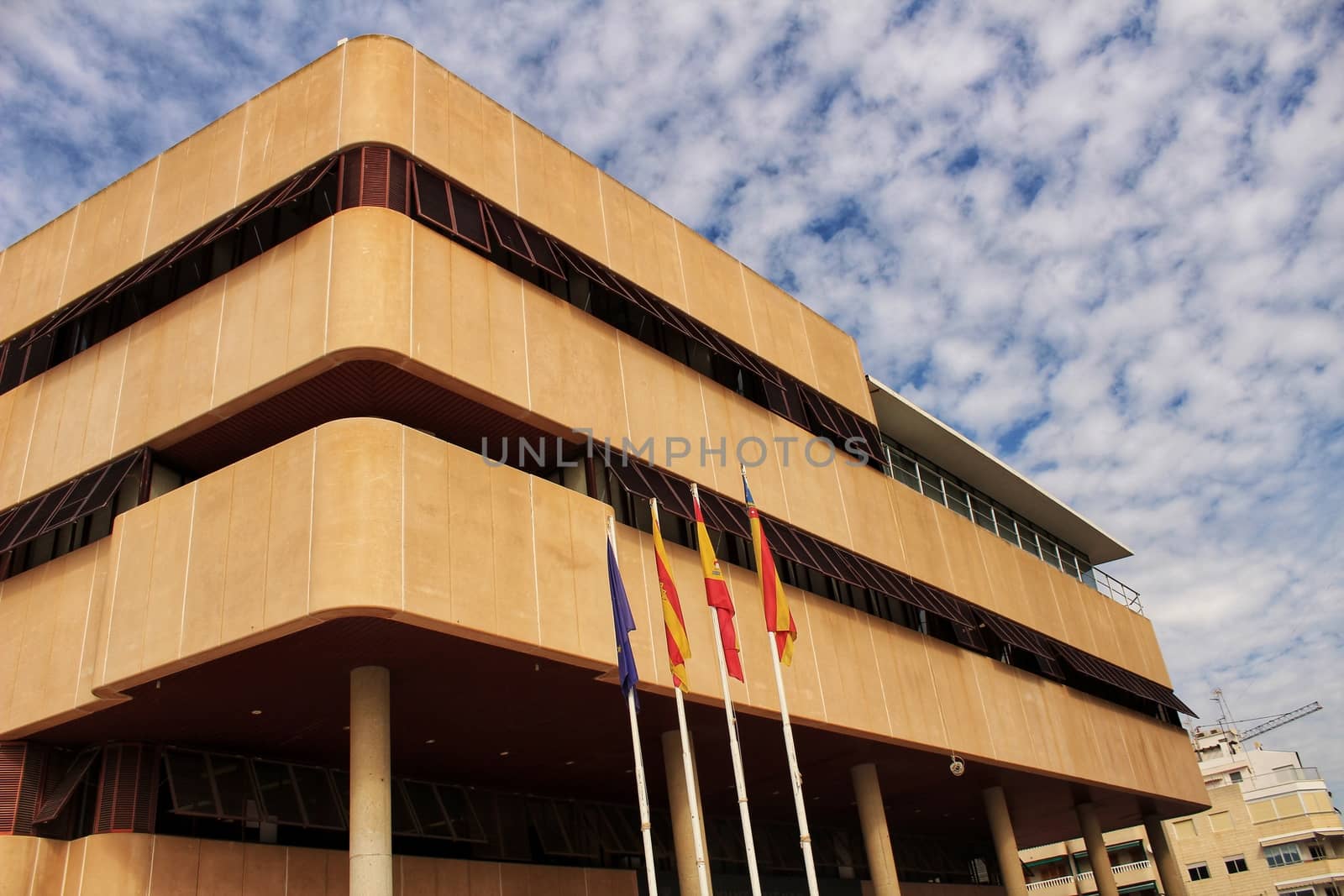 Santa Pola, Spain- February 16, 2018: Constitutional flags of Spain and Europe at the city hall in a cloudy day