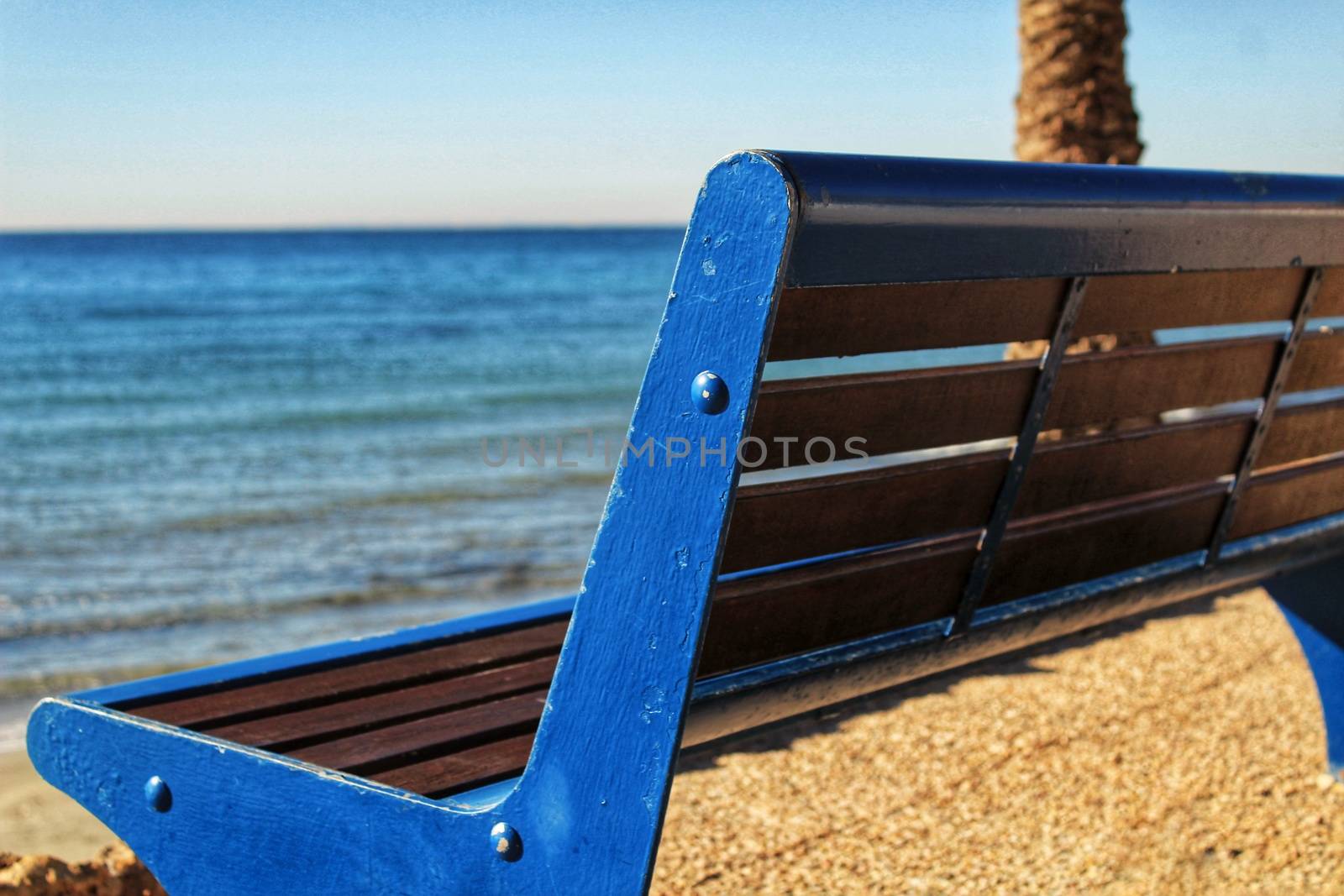 Blue bench with sea view on the beach in southern spain