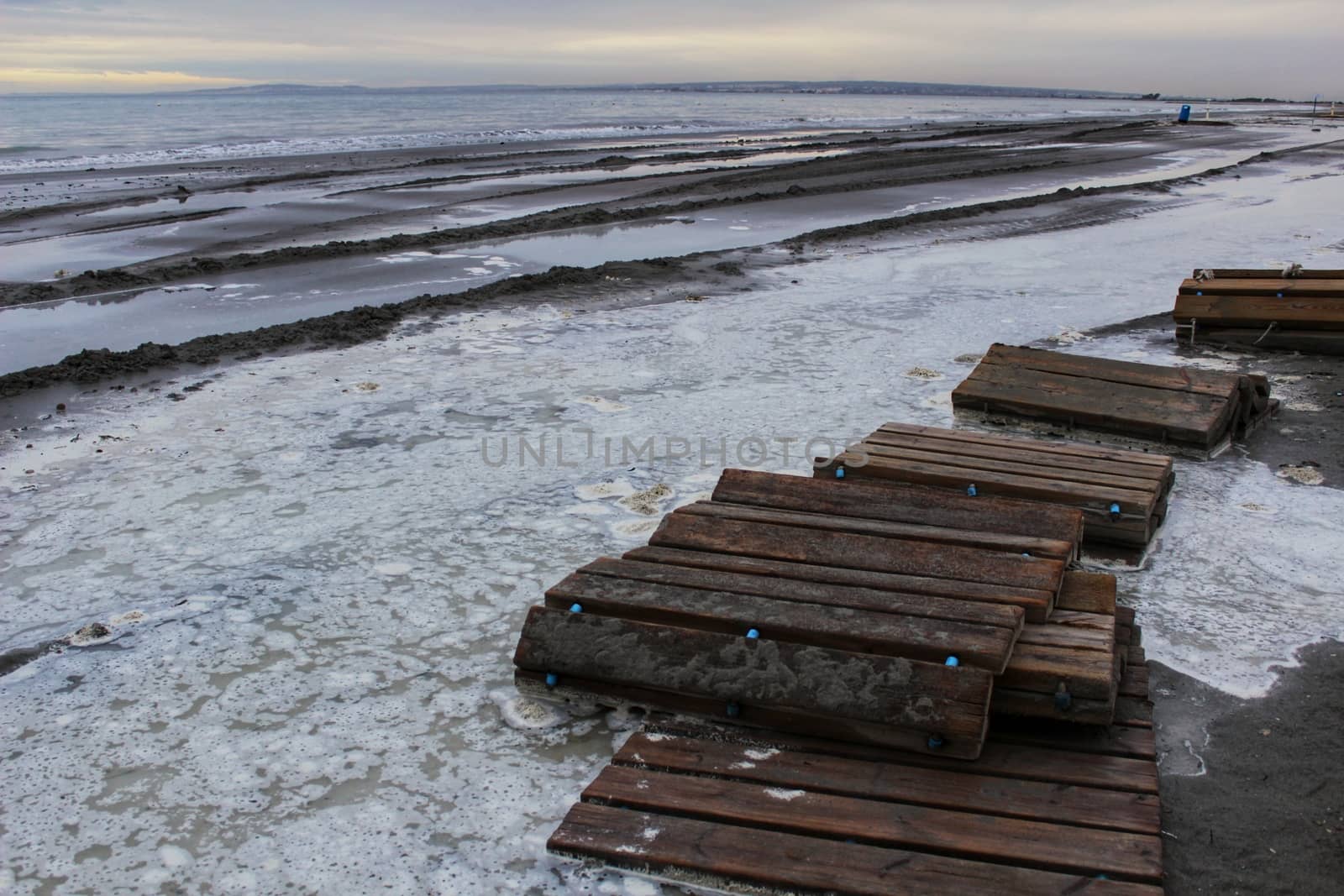 Beach flooded after the storm and broken wooden walkway in Alicante, Spain