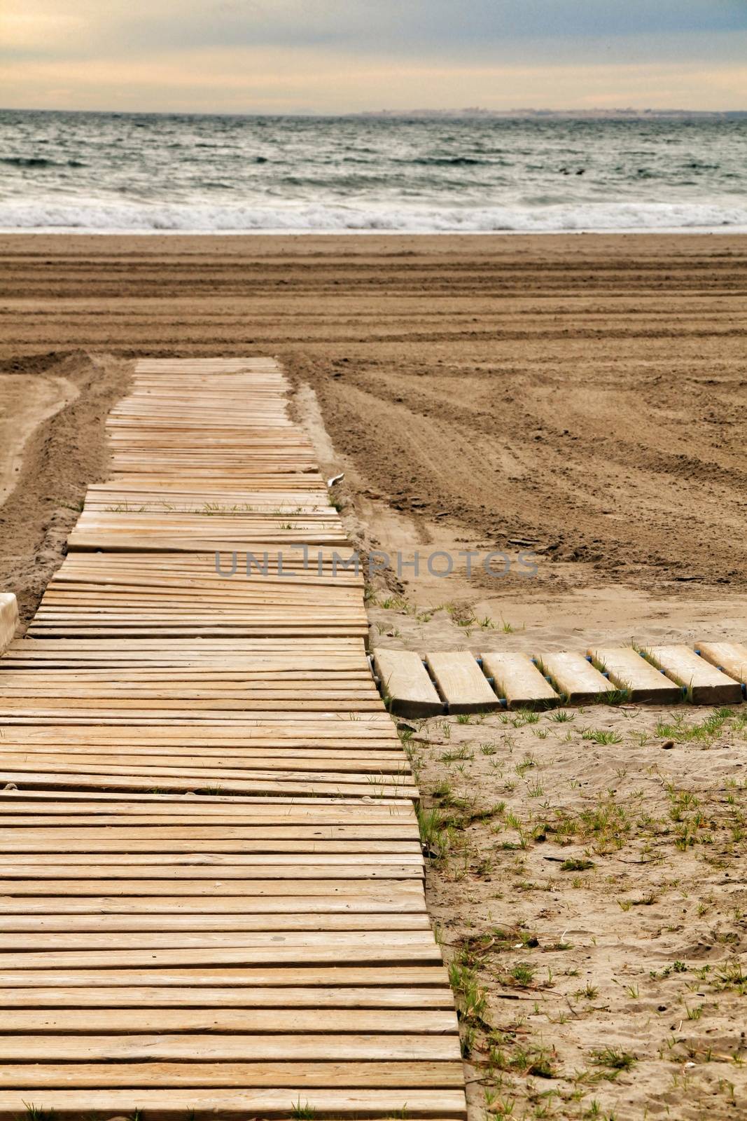 Wooden walkway to the beach in the morning in a cloudy day