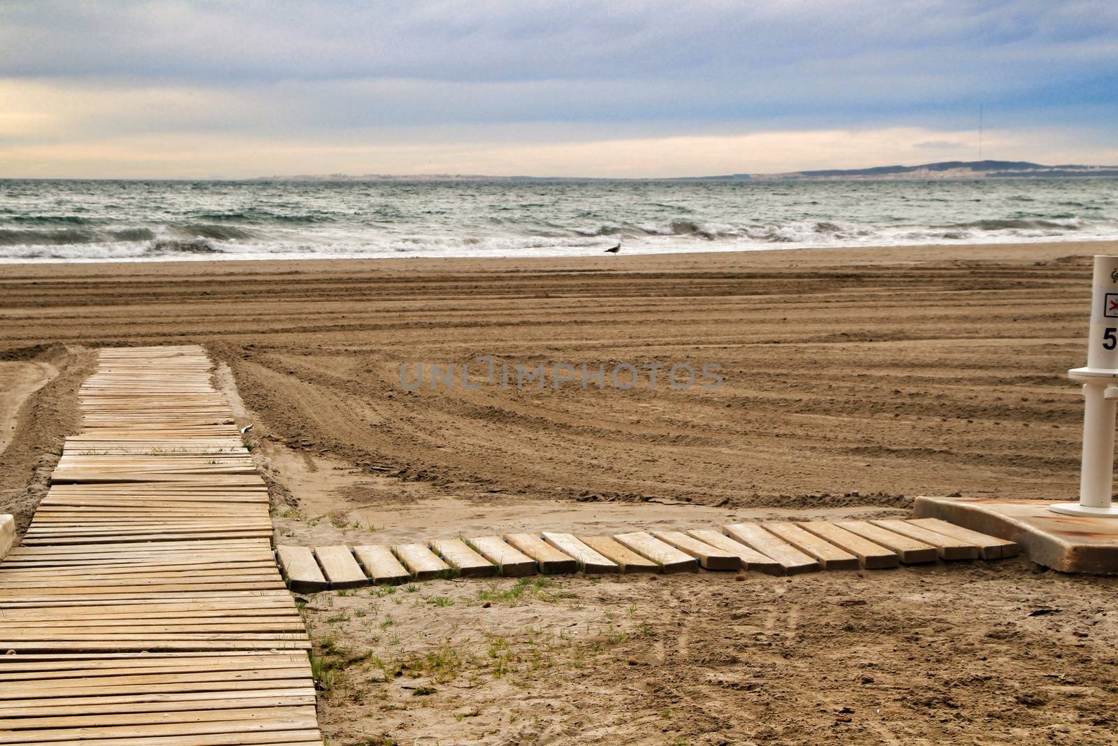 Wooden walkway to the beach in the morning in a cloudy day