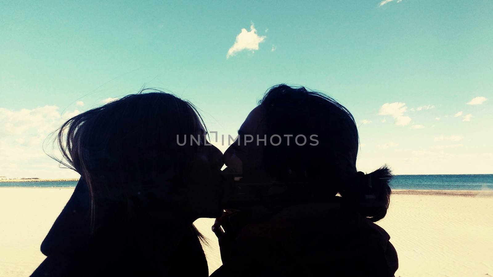 Lesbian couple kissing on the beach