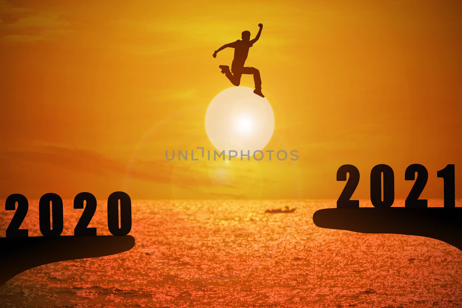 Silhouette of young man jumping between 2020 and 2021 years with beautiful sunset at the sea.