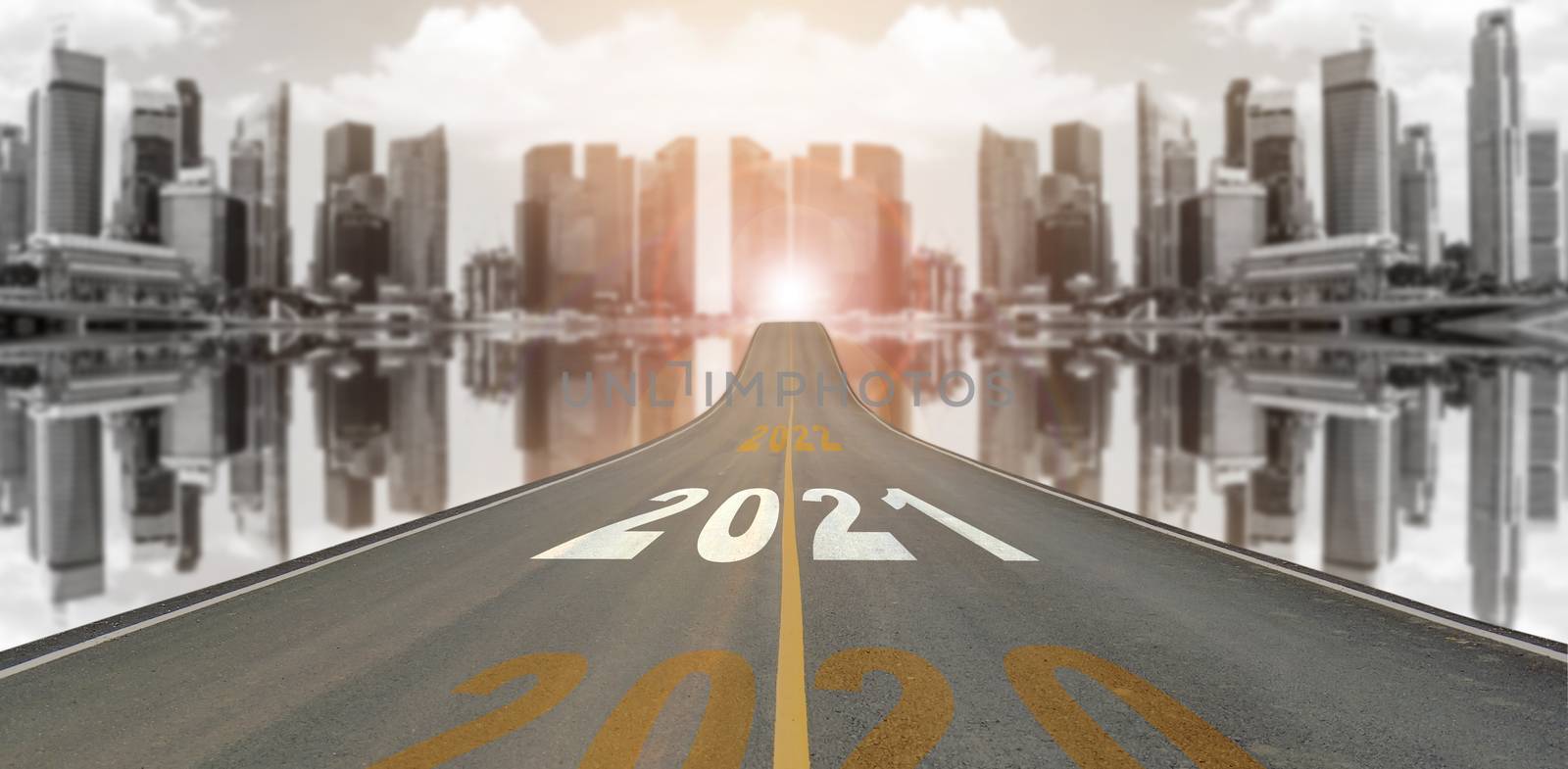 The number 2021 symbol represents the new year on the road heading to the city with beautiful skyscrapers background, New Year's and business target concepts.