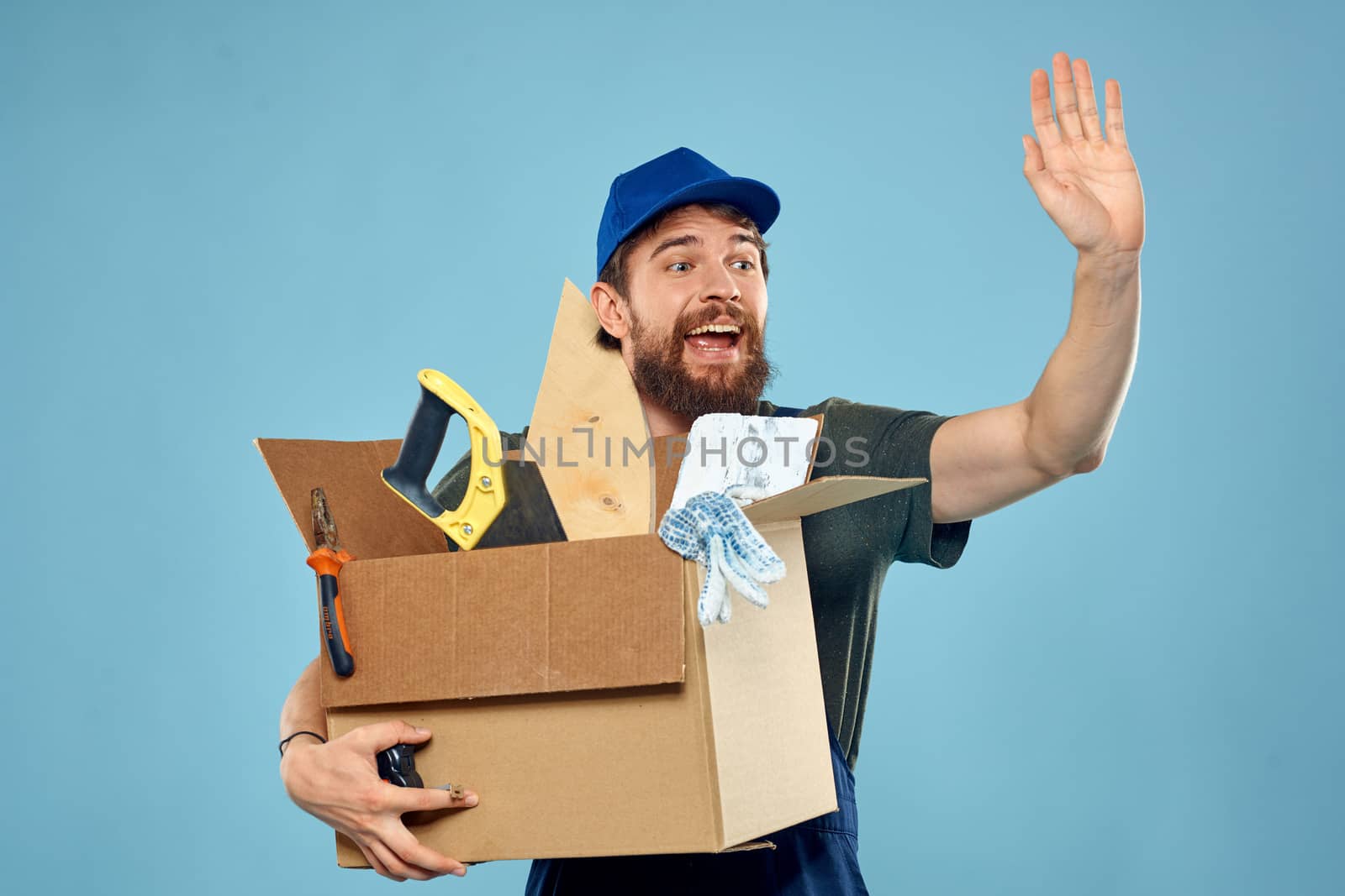 Worker man in uniform box tools construction blue background by SHOTPRIME