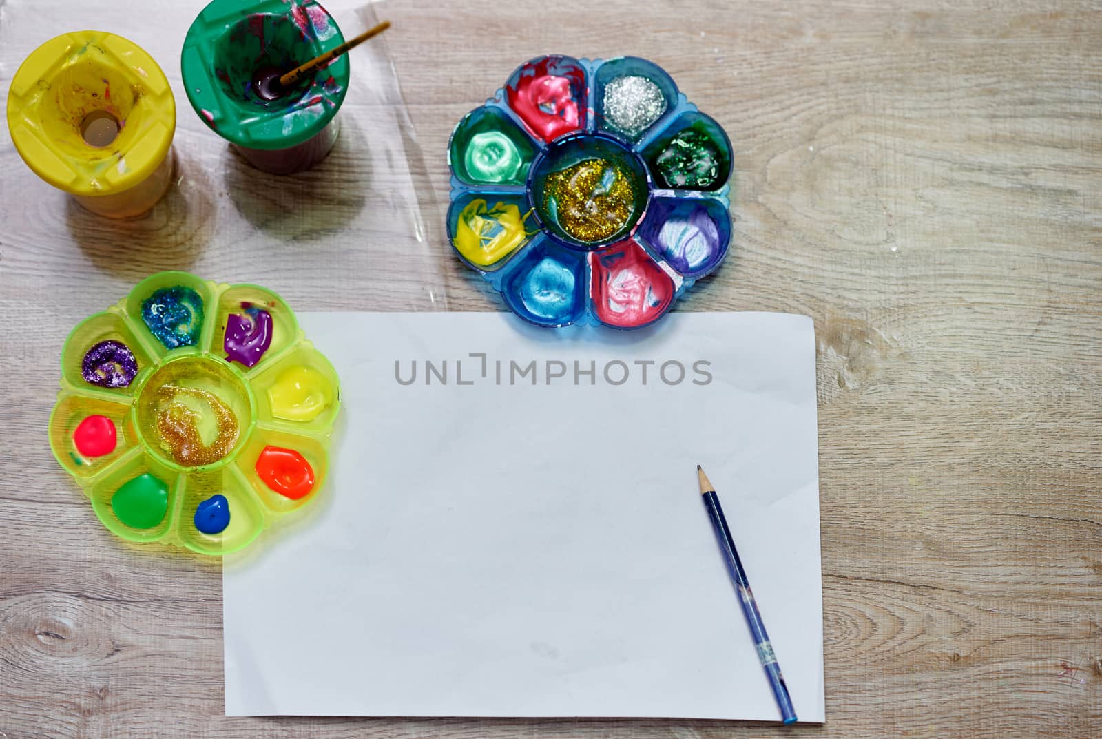 mock up paper and color palettes ,brushes and bottle of water color on wood table,top view