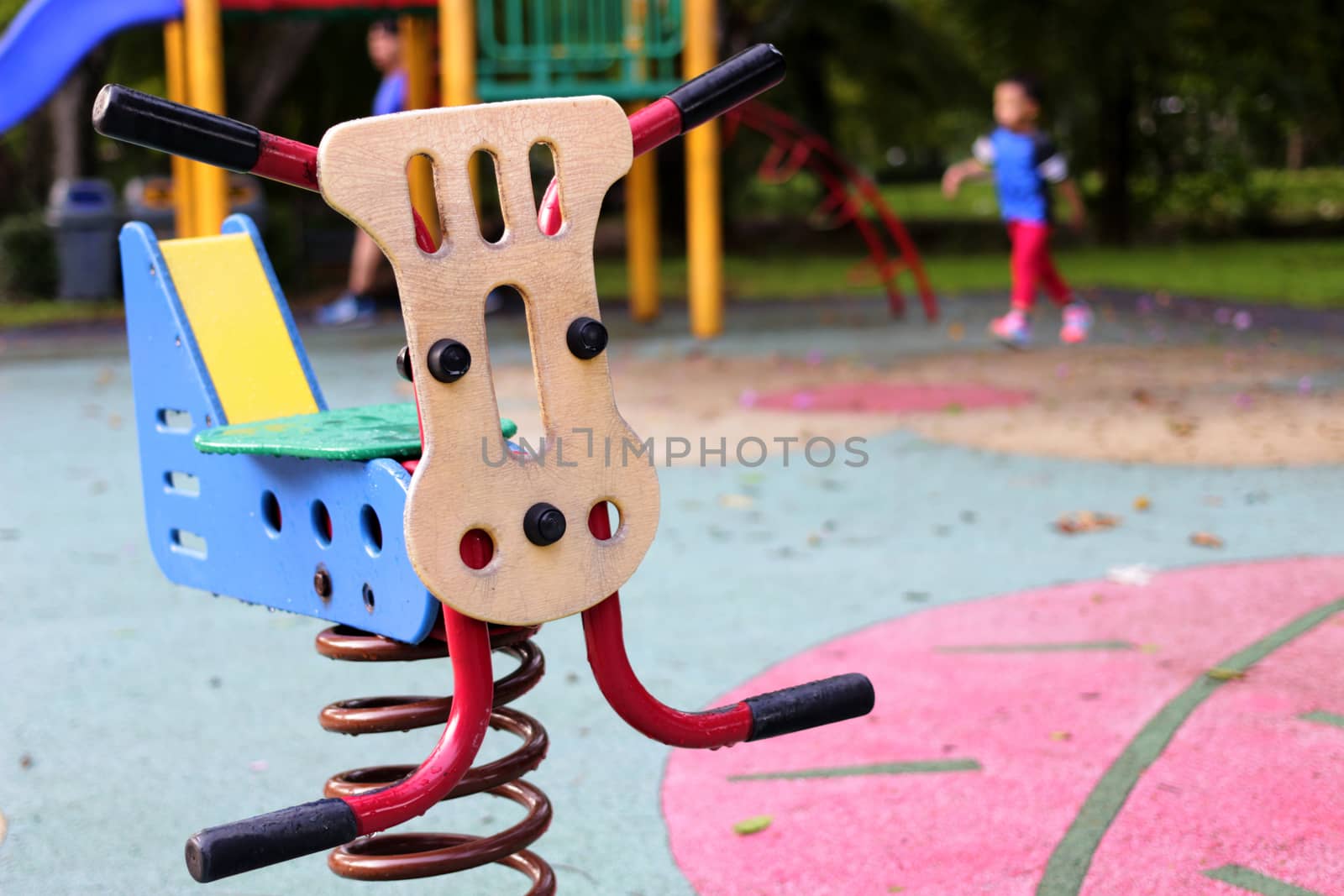 see saw toy in public playground in park on blur playground background
