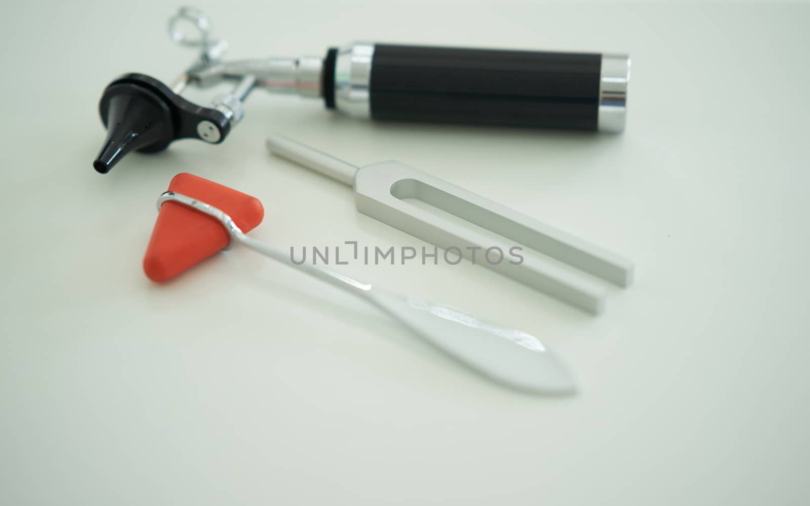 Tuning fork and Blur Otoscope and hammer jerk on white floor ,top view with copy space