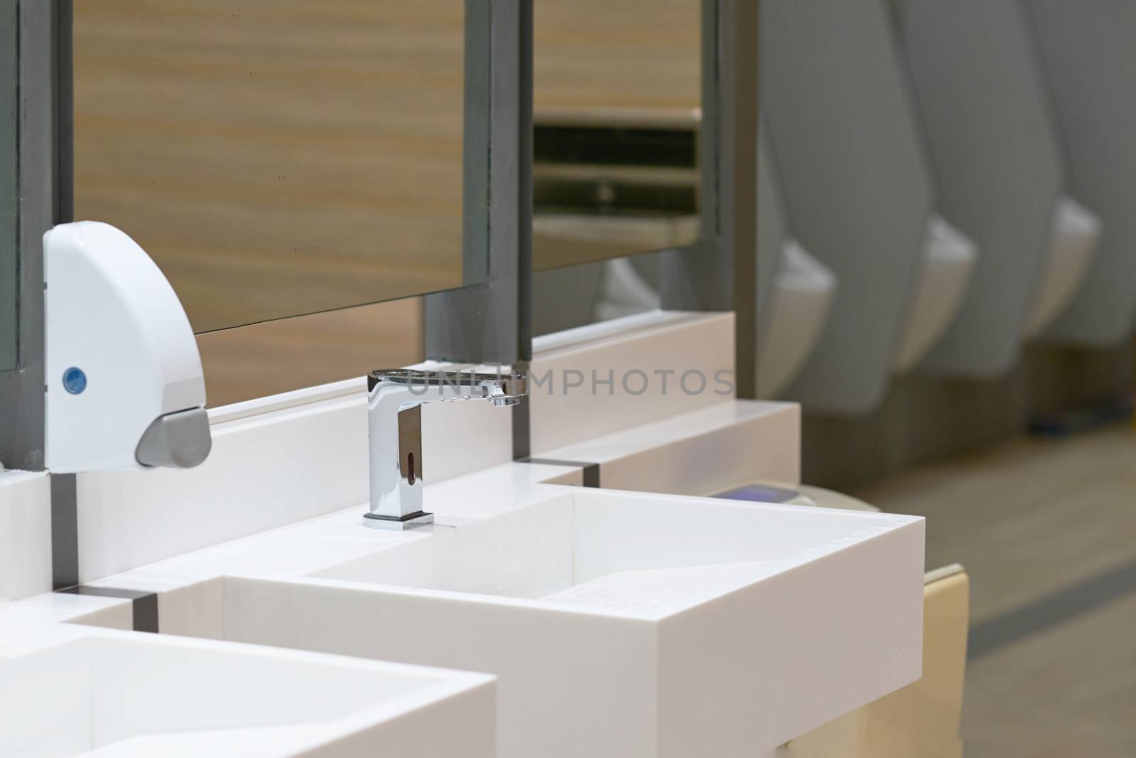 Toilet sink for wash hand with soap drop on blur urinal background