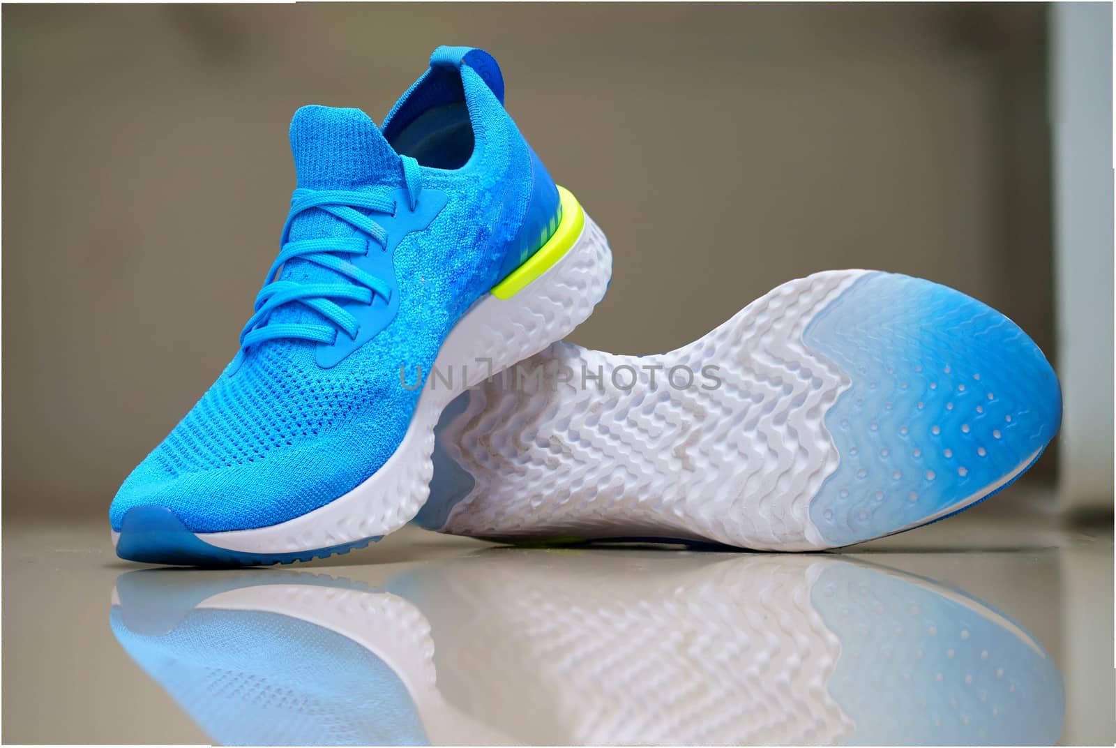 blue sport or running shoes for runner with reflection on isolated blur background