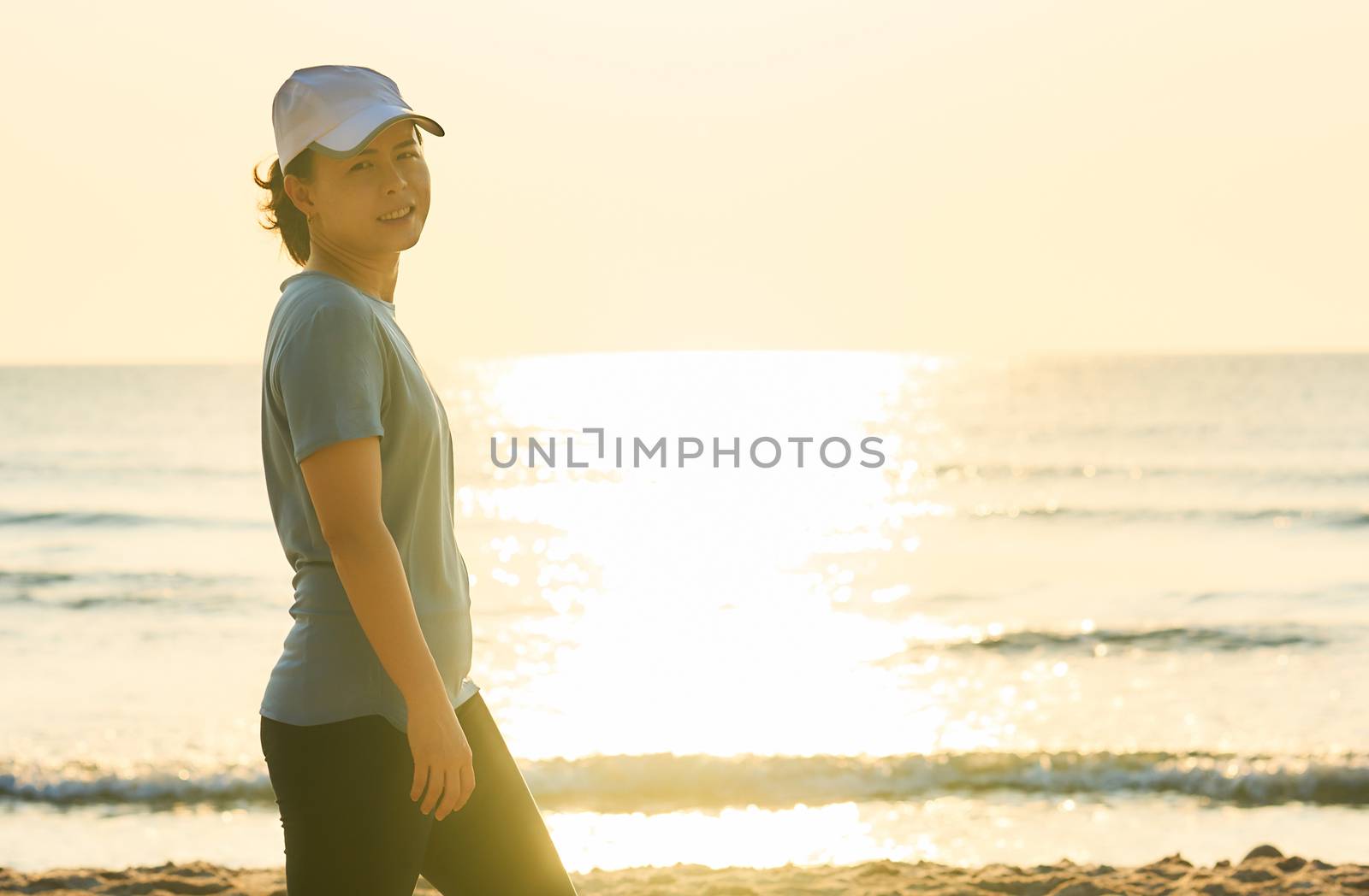 Woman on sport suit on beach reflect background