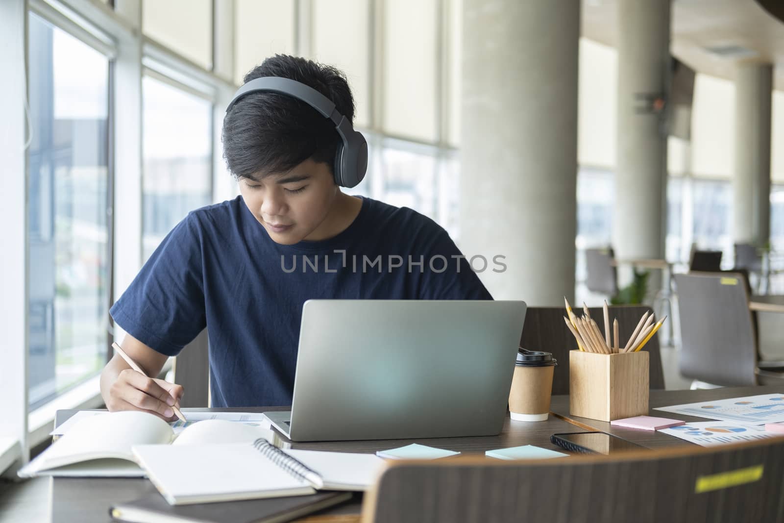 Young collage student using computer and mobile device studying online. Education and online learning. 