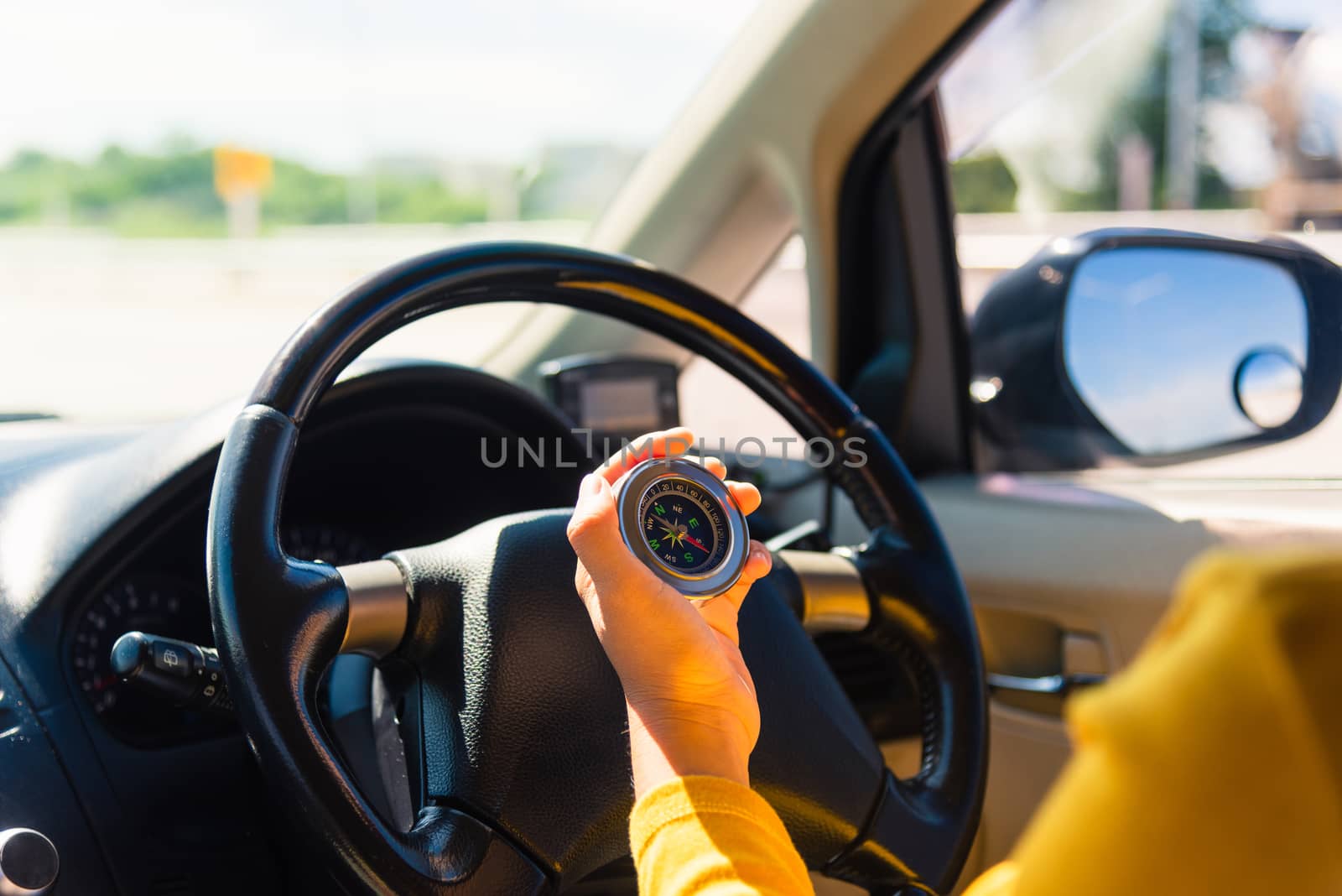 Asian woman inside a car and using compass to navigate while driving the car she find navigation location to go, Transportation and vehicle concept